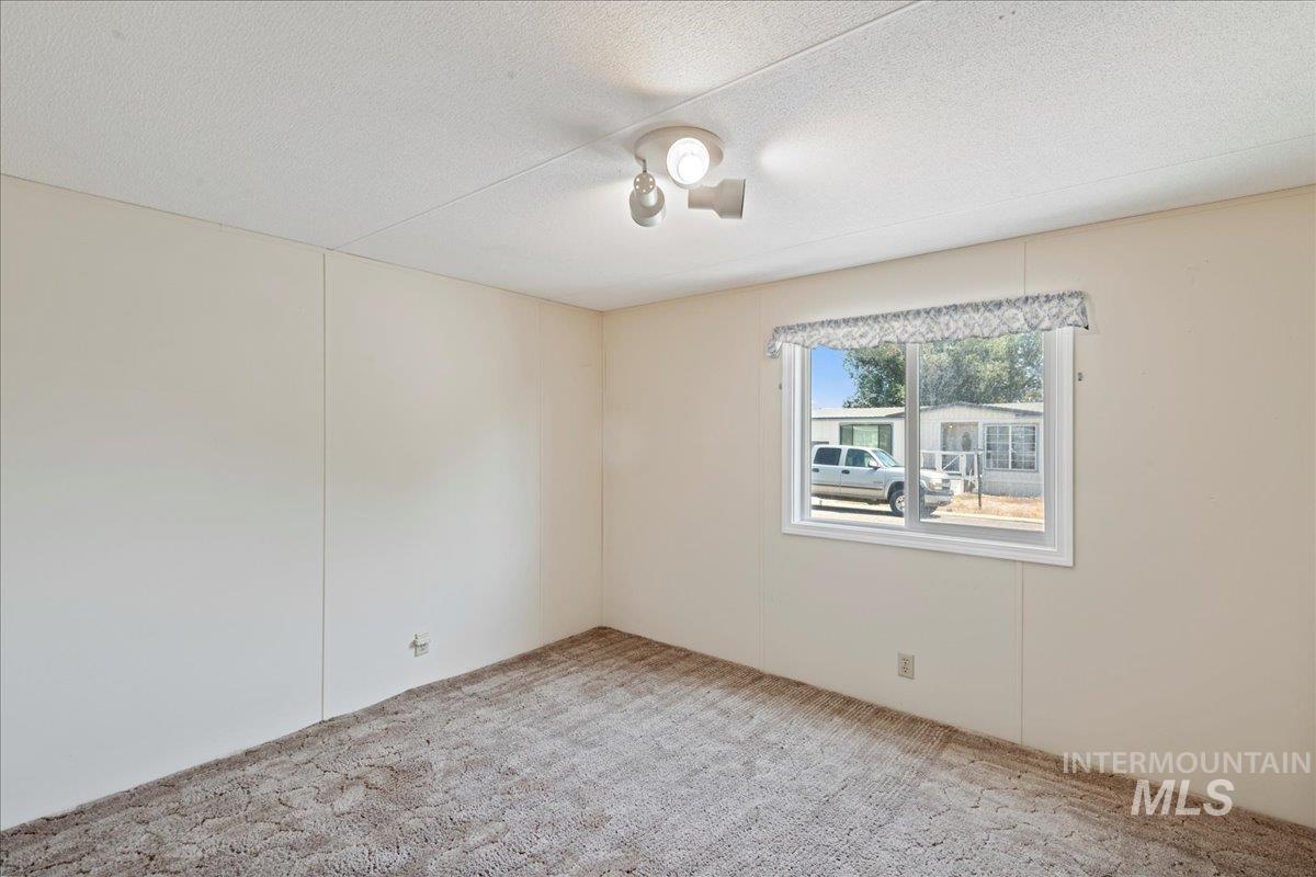Empty room featuring carpet flooring and a textured ceiling