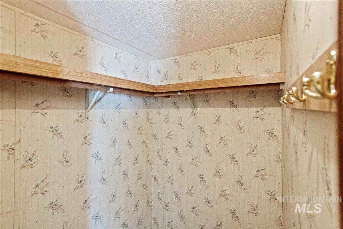 Detailed view of a textured ceiling and wallpapered walls