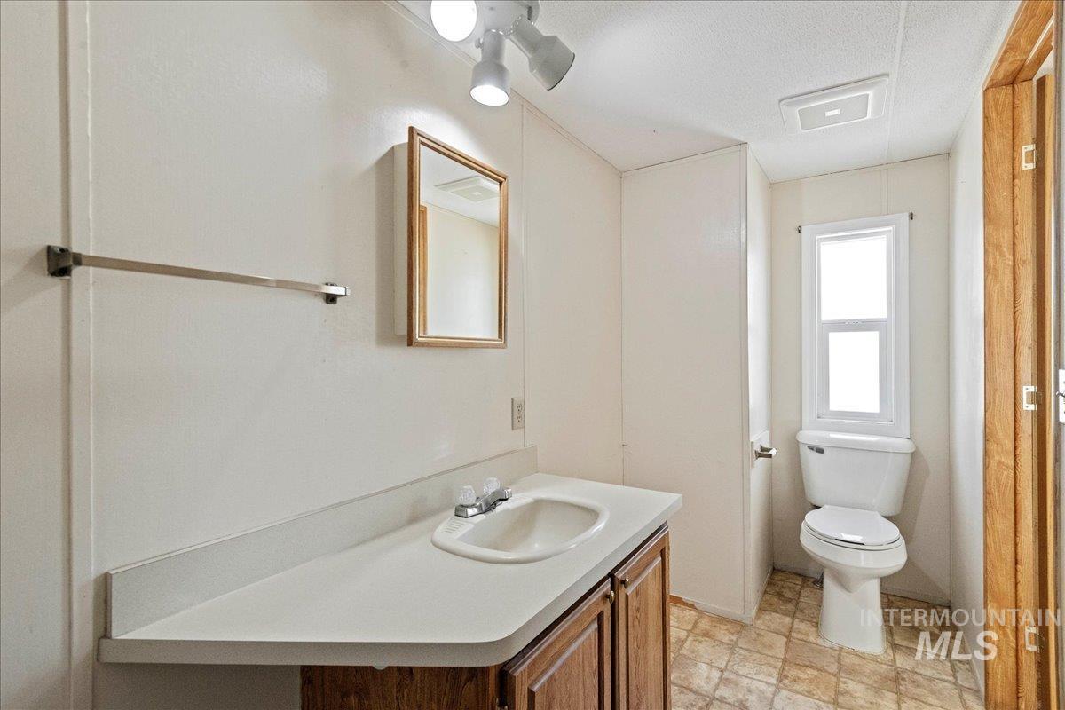 Half bathroom featuring vanity and a textured ceiling