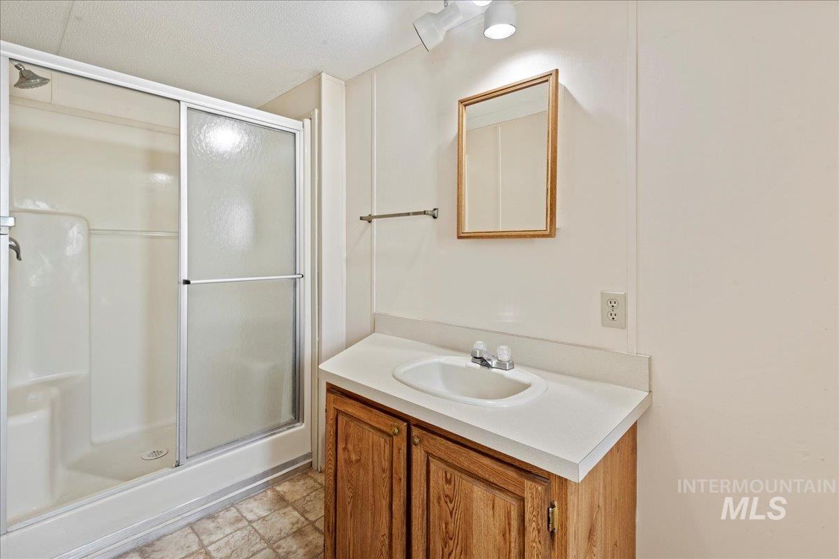 Full bath featuring a shower stall and vanity