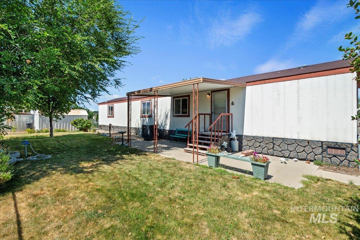 Rear view of property featuring a yard and a patio area