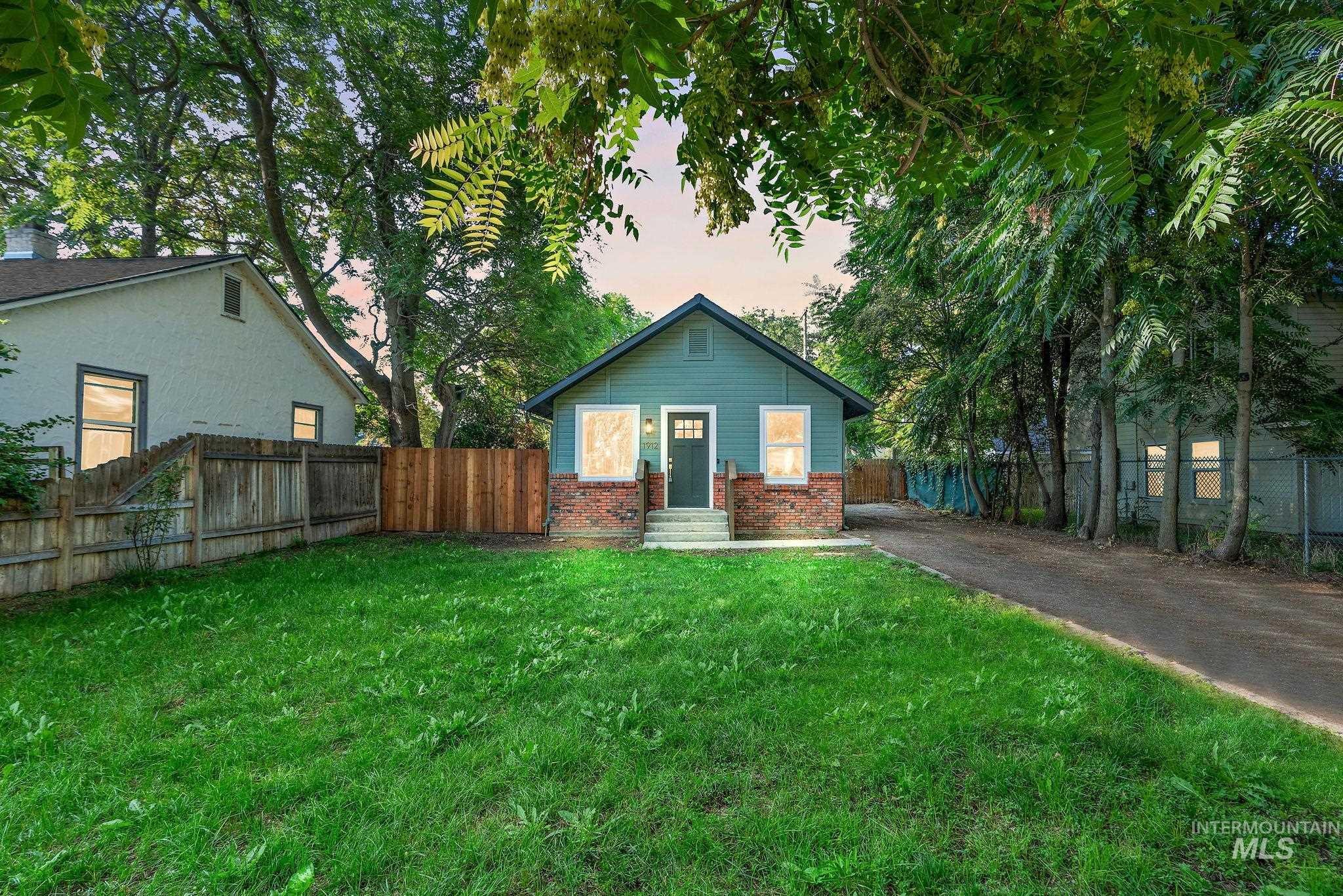 Back of property at dusk featuring brick siding