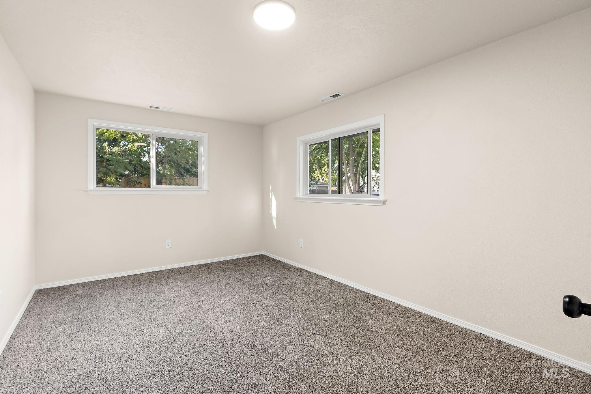 Carpeted empty room featuring baseboards