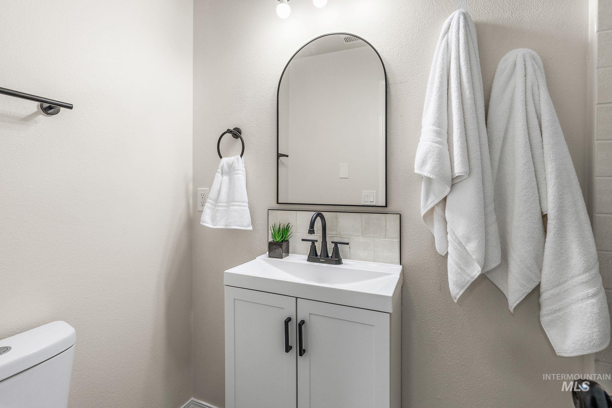Bathroom featuring a textured wall and vanity