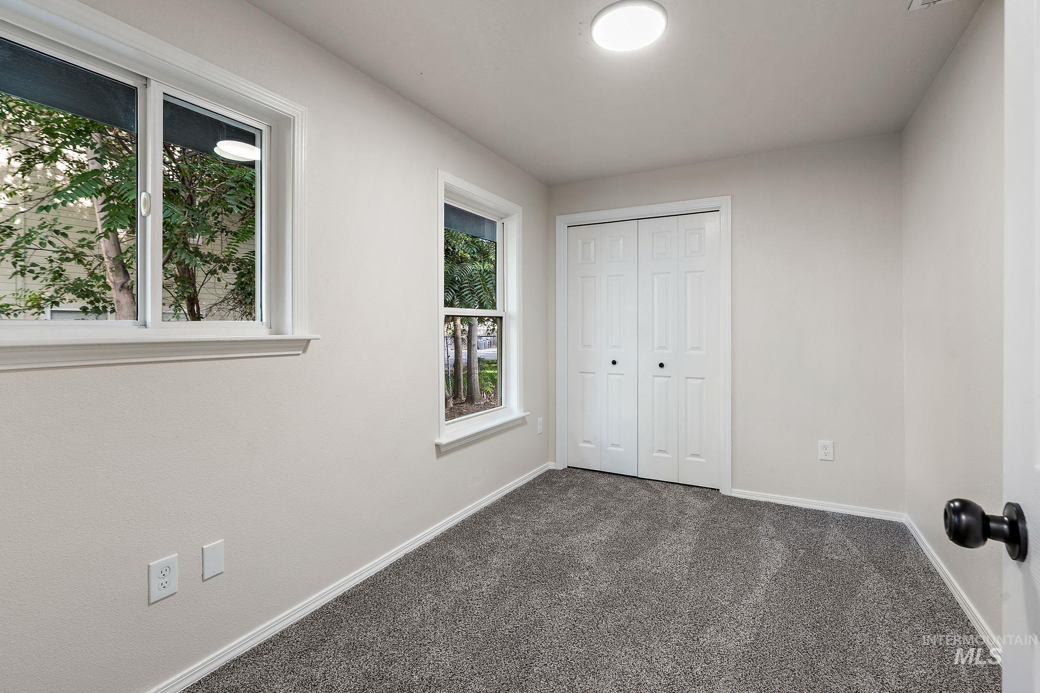 Unfurnished bedroom with dark carpet and a closet