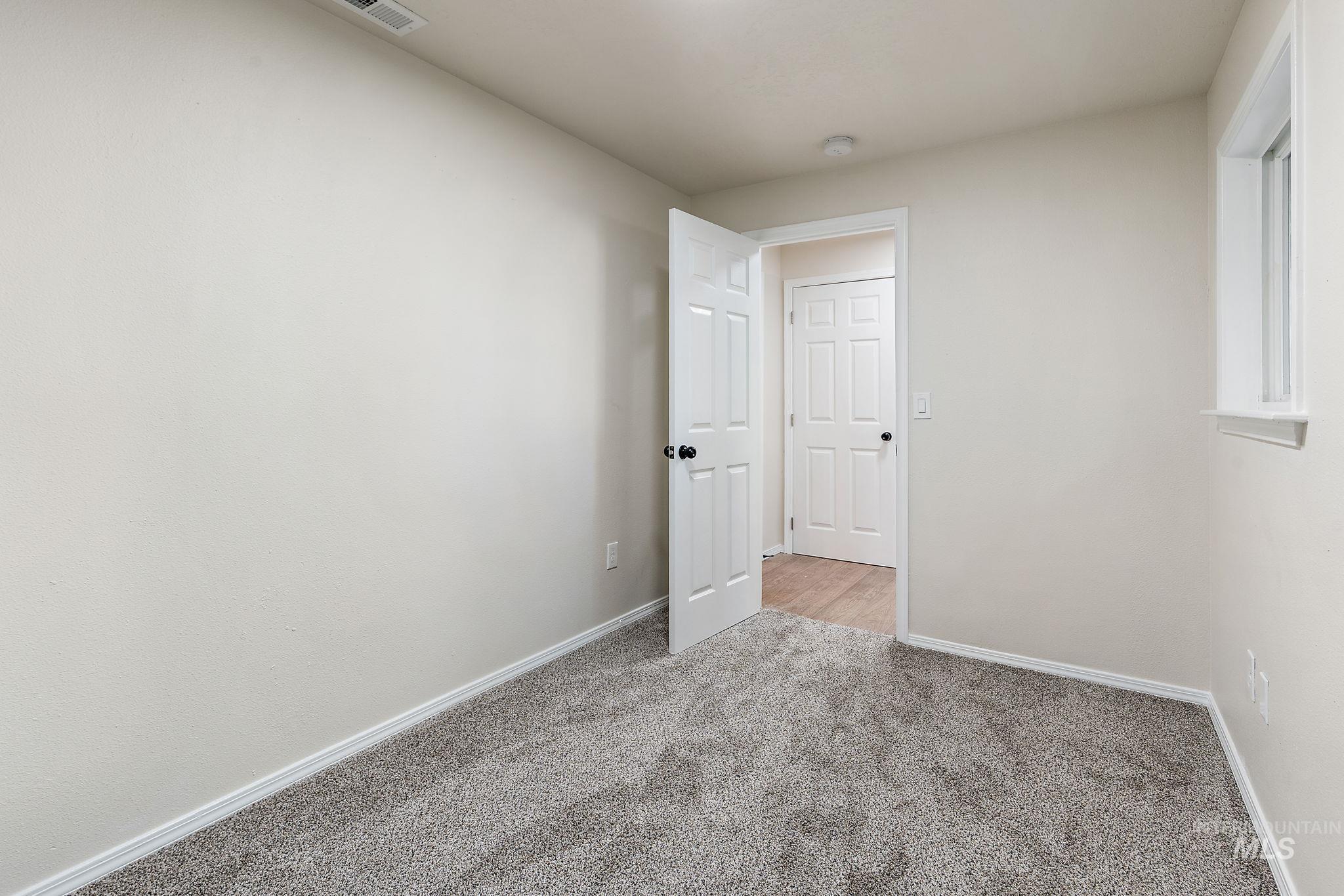 Spare room featuring carpet floors and baseboards