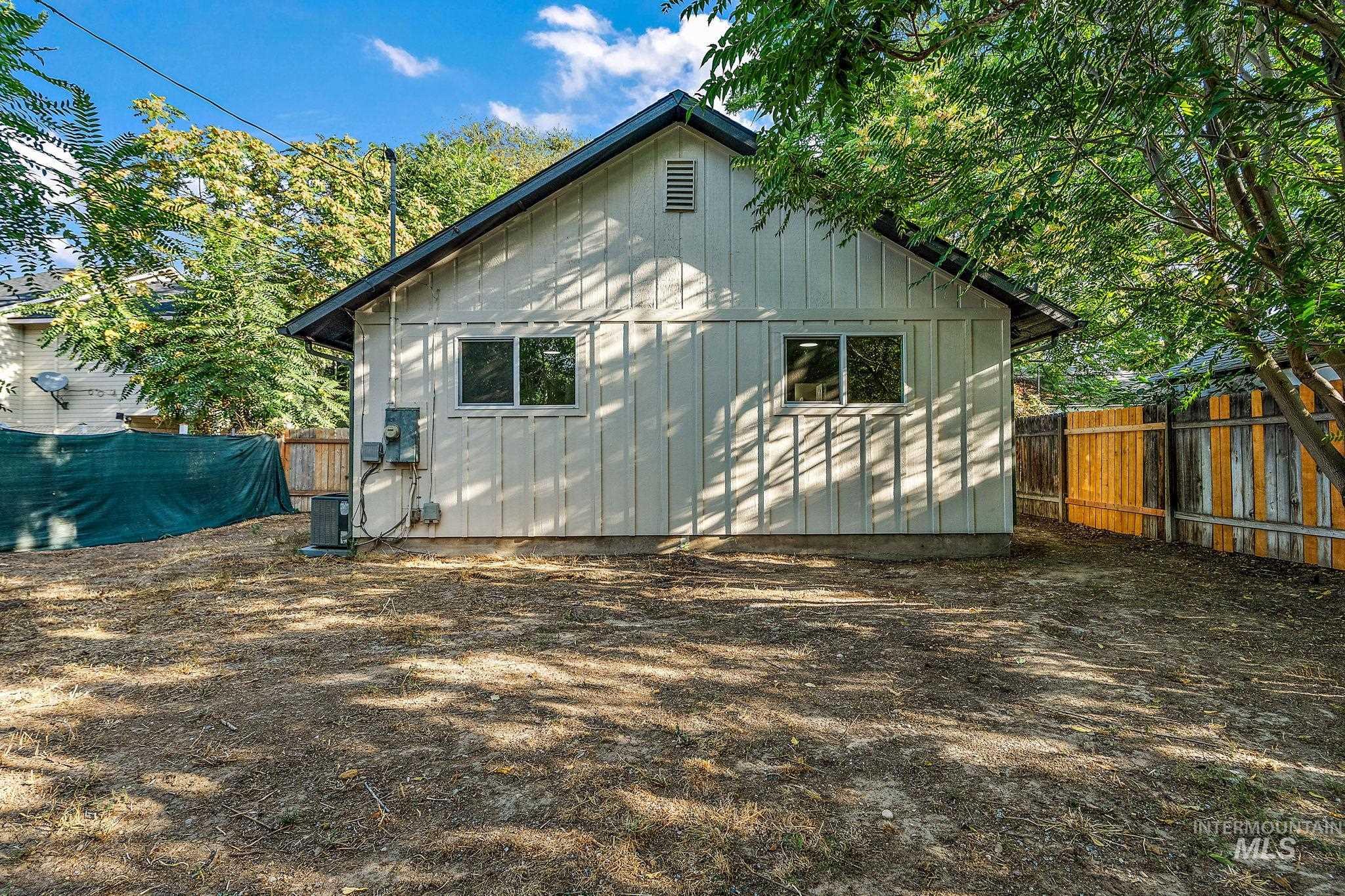 Rear view of house featuring a fenced backyard and board and batten siding
