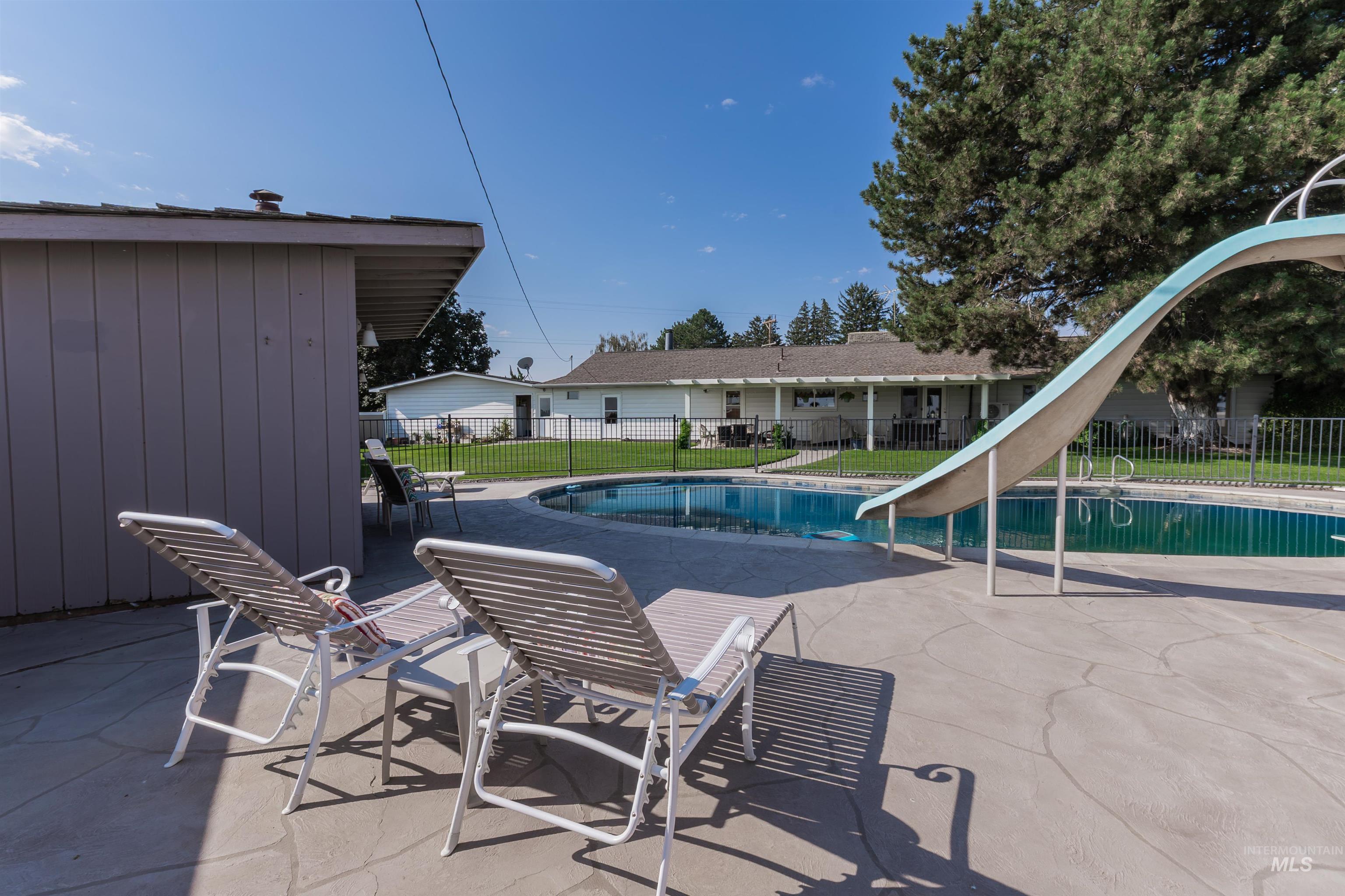View of swimming pool with a patio and a water slide