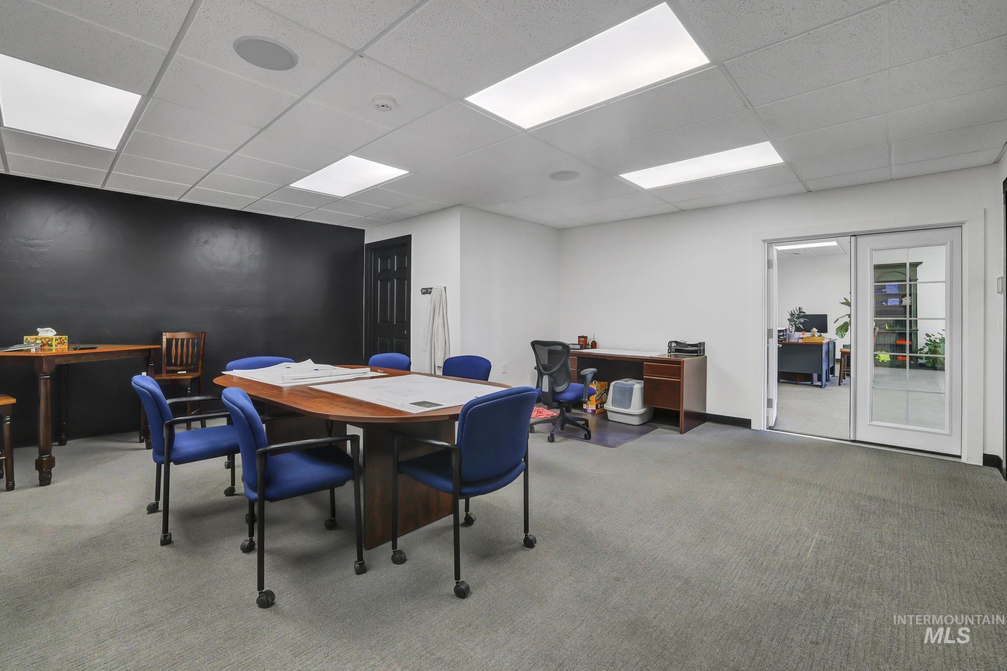 Dining room featuring carpet floors, a drop ceiling, and a desk
