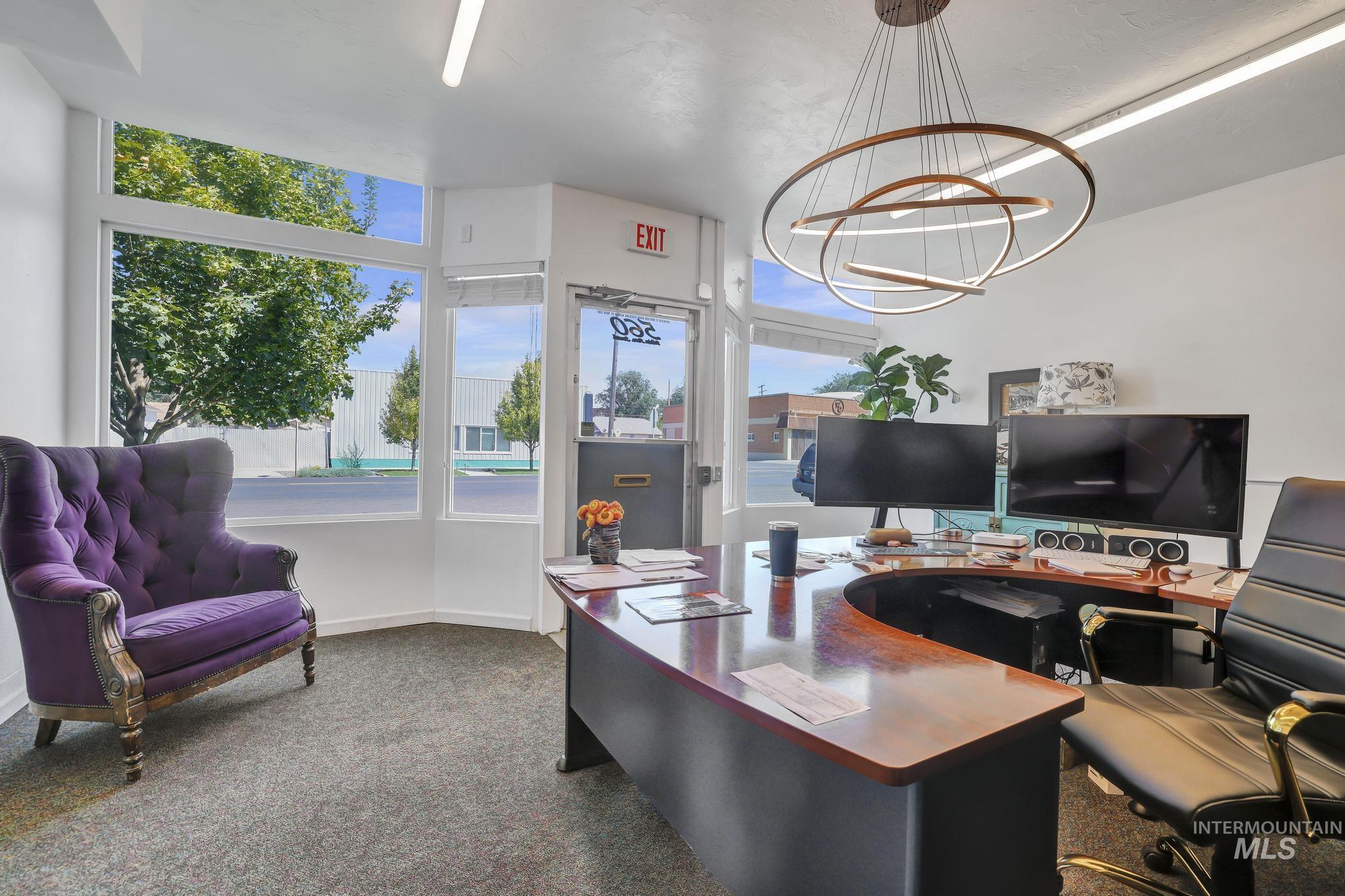 Home office featuring dark carpet and a chandelier
