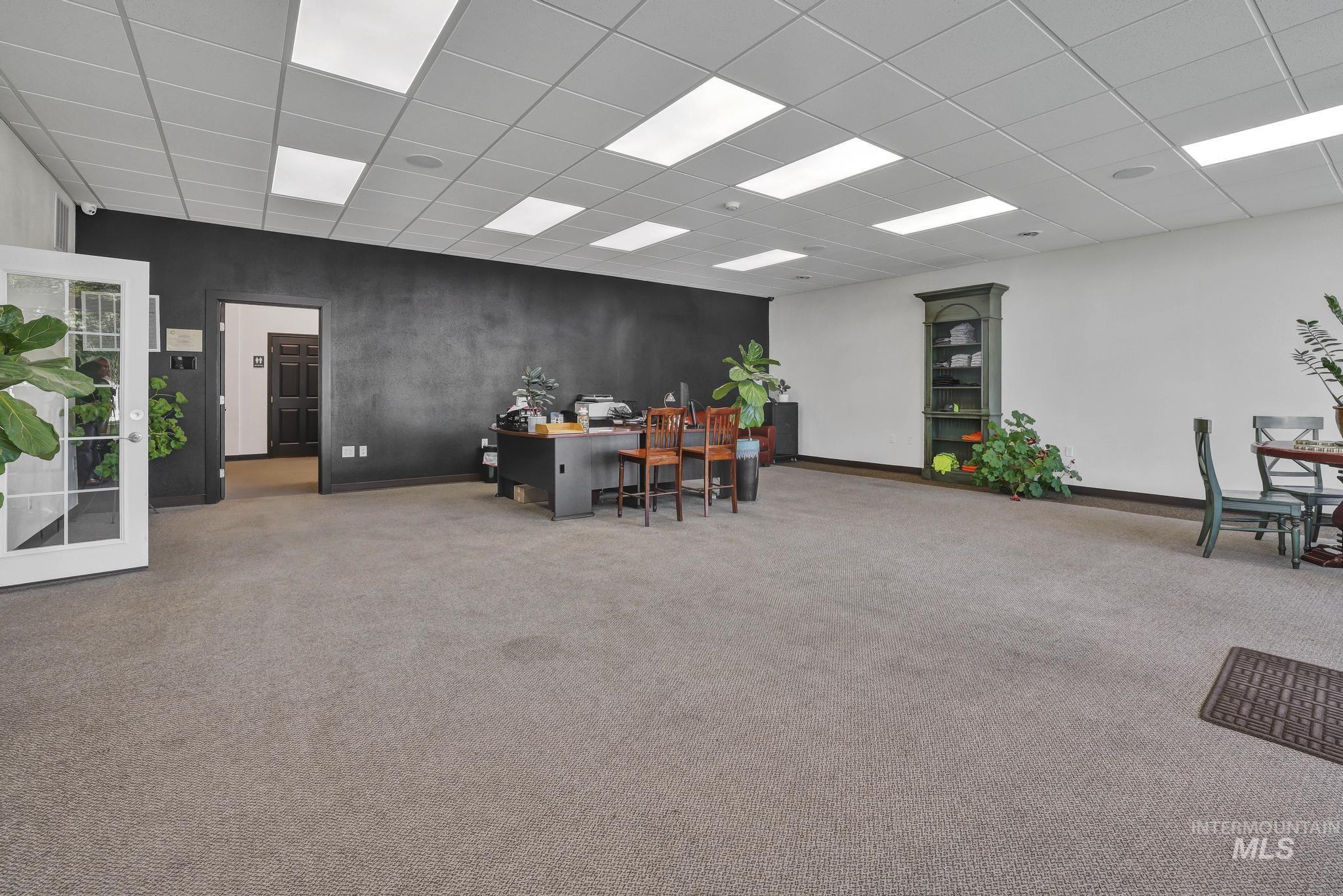 Home office featuring a drop ceiling and carpet