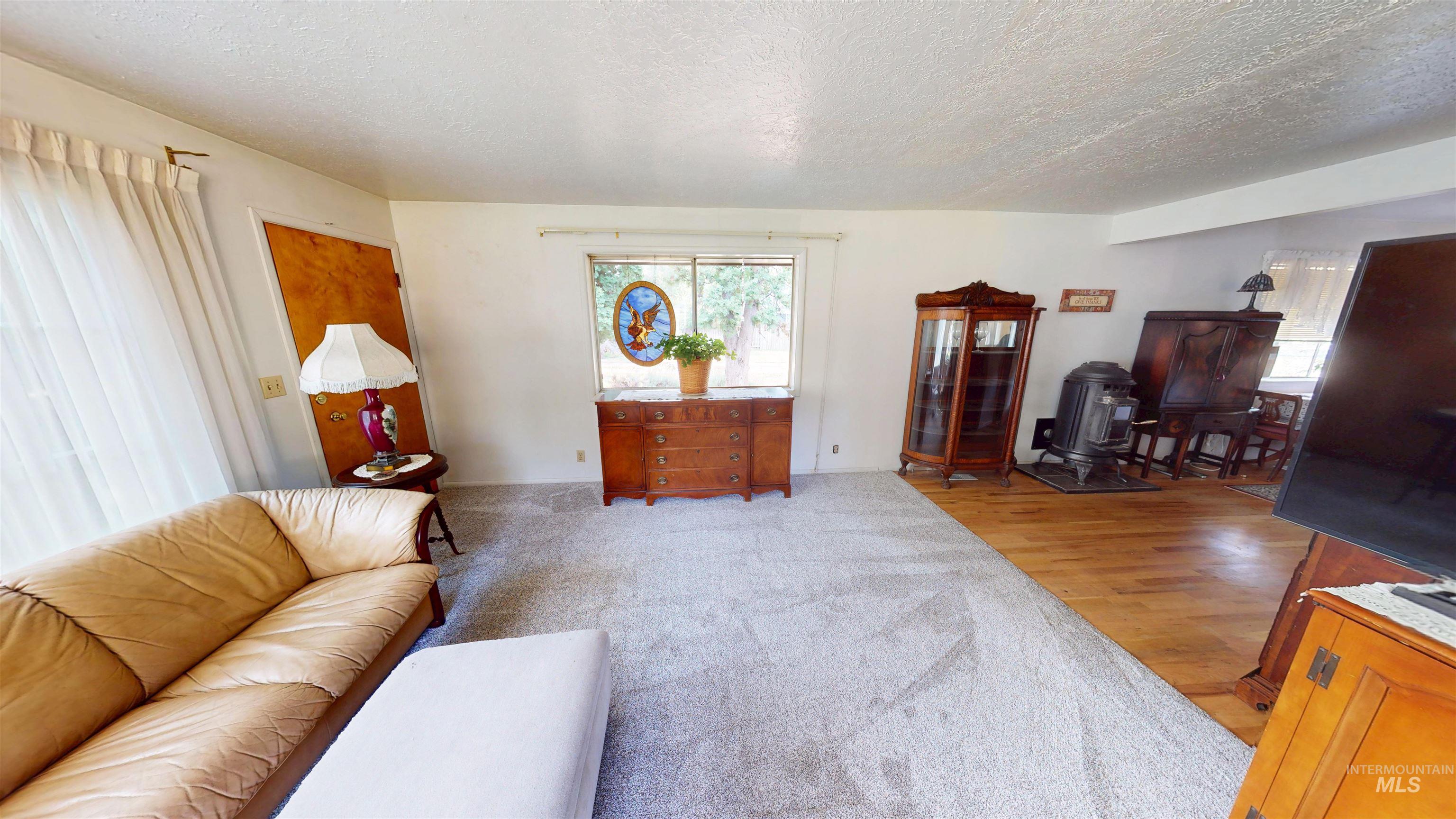Living area featuring plenty of natural light, a textured ceiling, and light wood finished floors