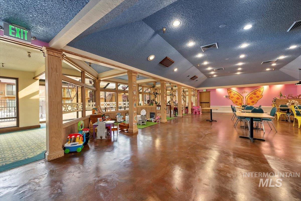 Community lobby with a textured ceiling and vaulted ceiling