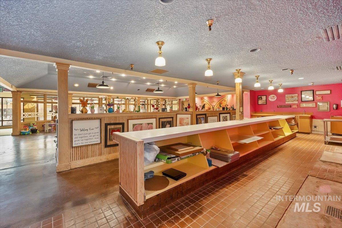 Bar area featuring a textured ceiling, light countertops, and track lighting