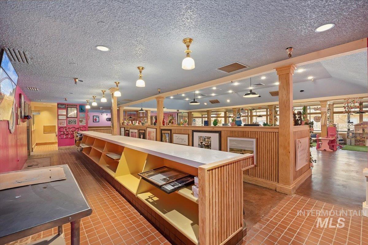 Bar featuring a textured ceiling and light countertops
