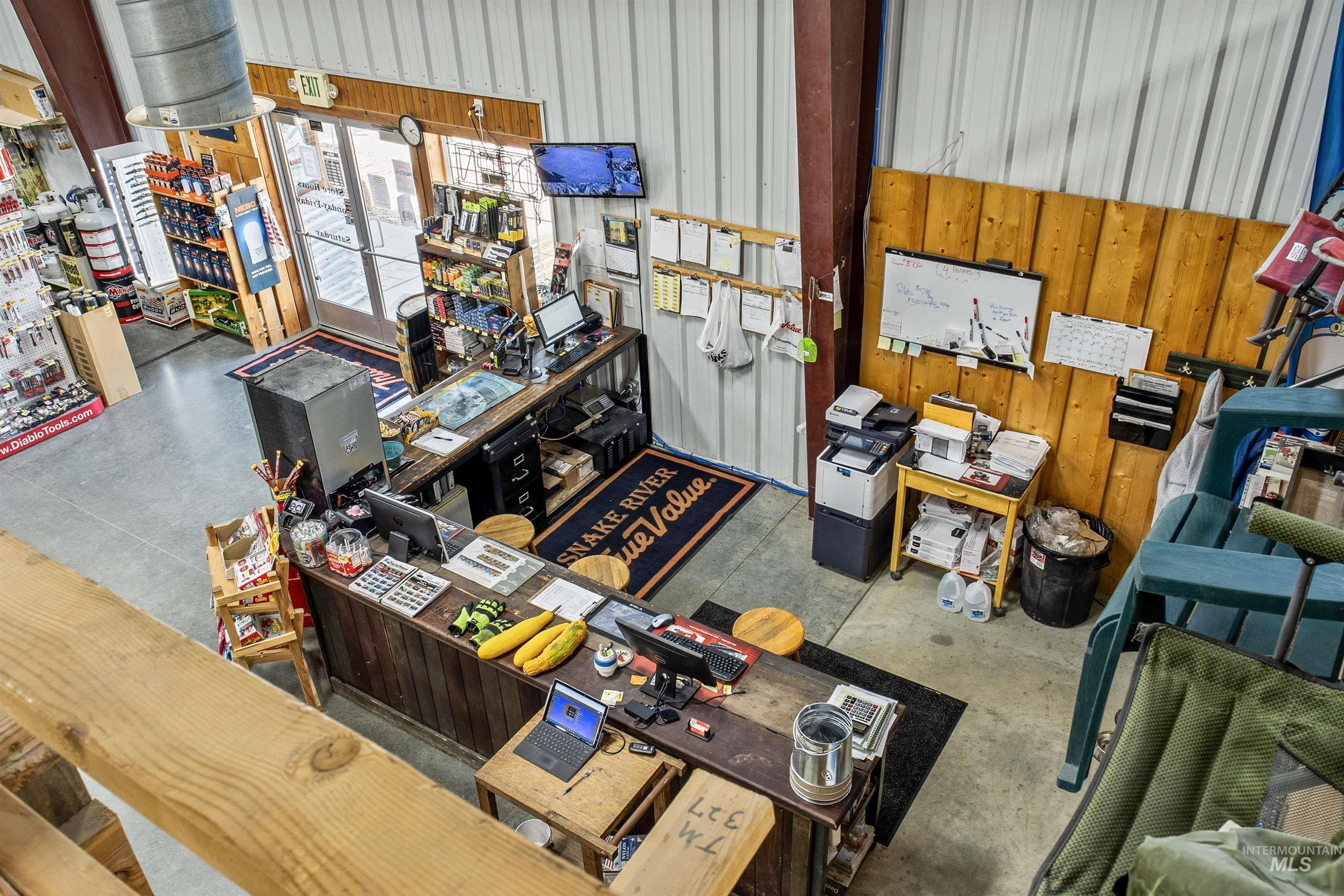 Misc room featuring concrete flooring, a workshop area, and wooden walls
