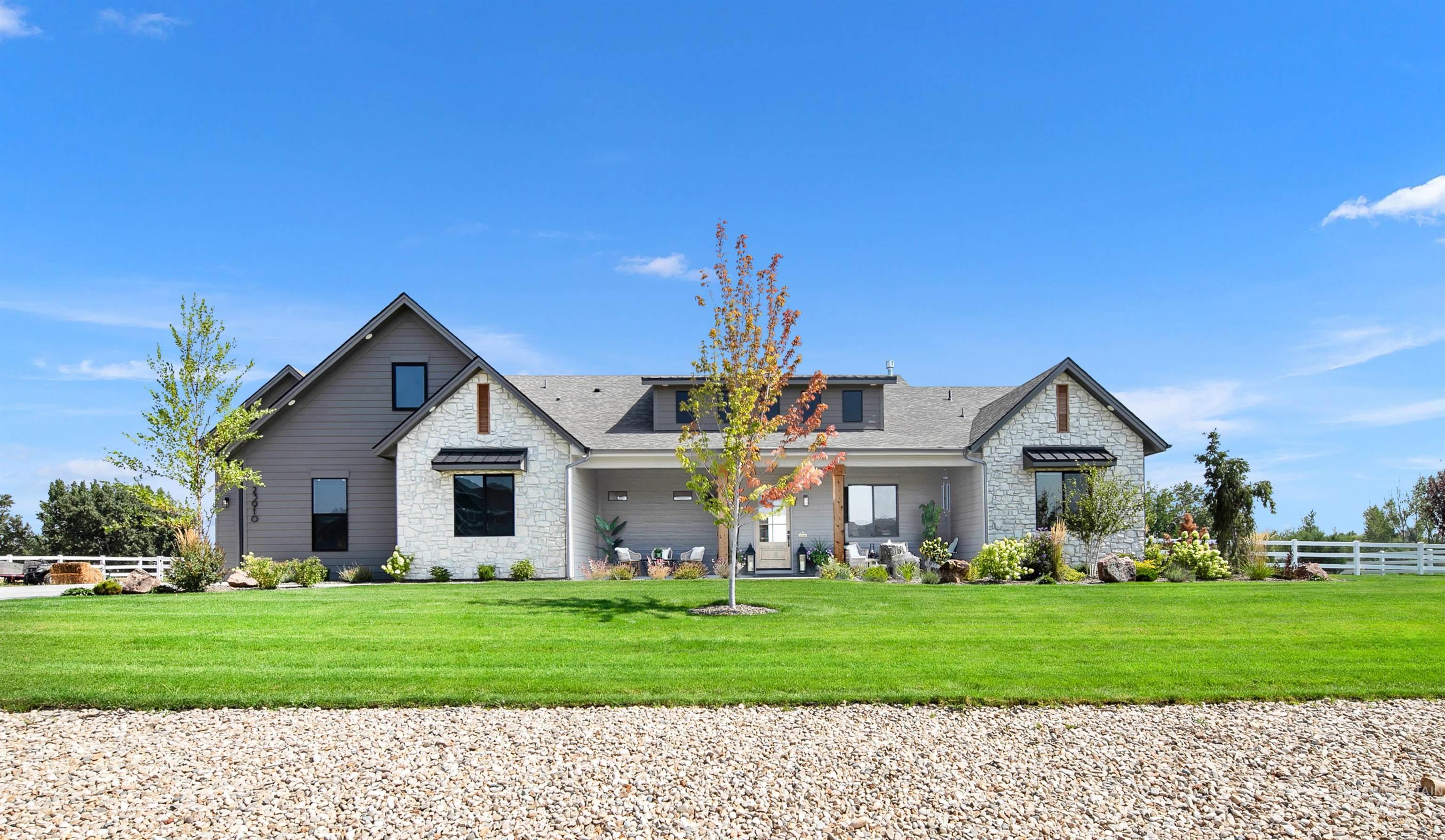 View of front of property with stone siding and a shingled roof