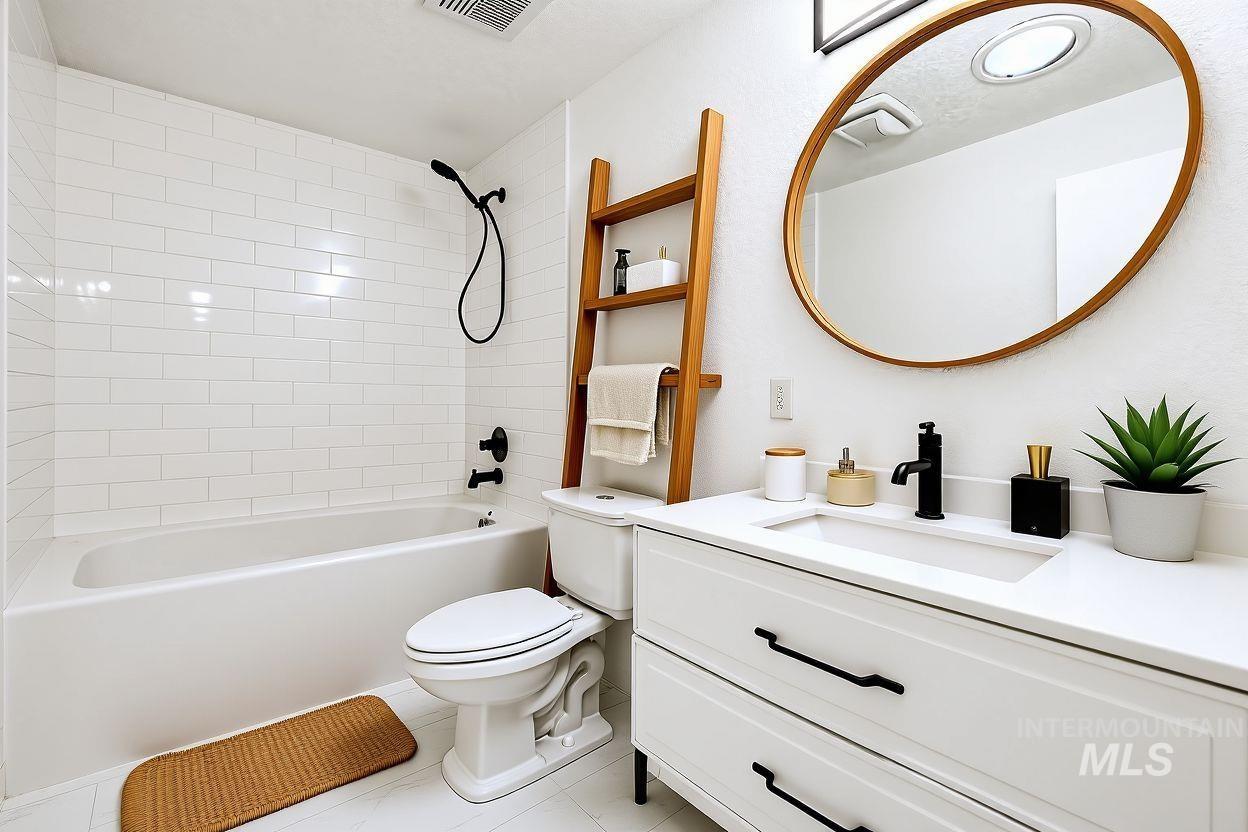 Bathroom with tub / shower combination, vanity, and light tile patterned floors