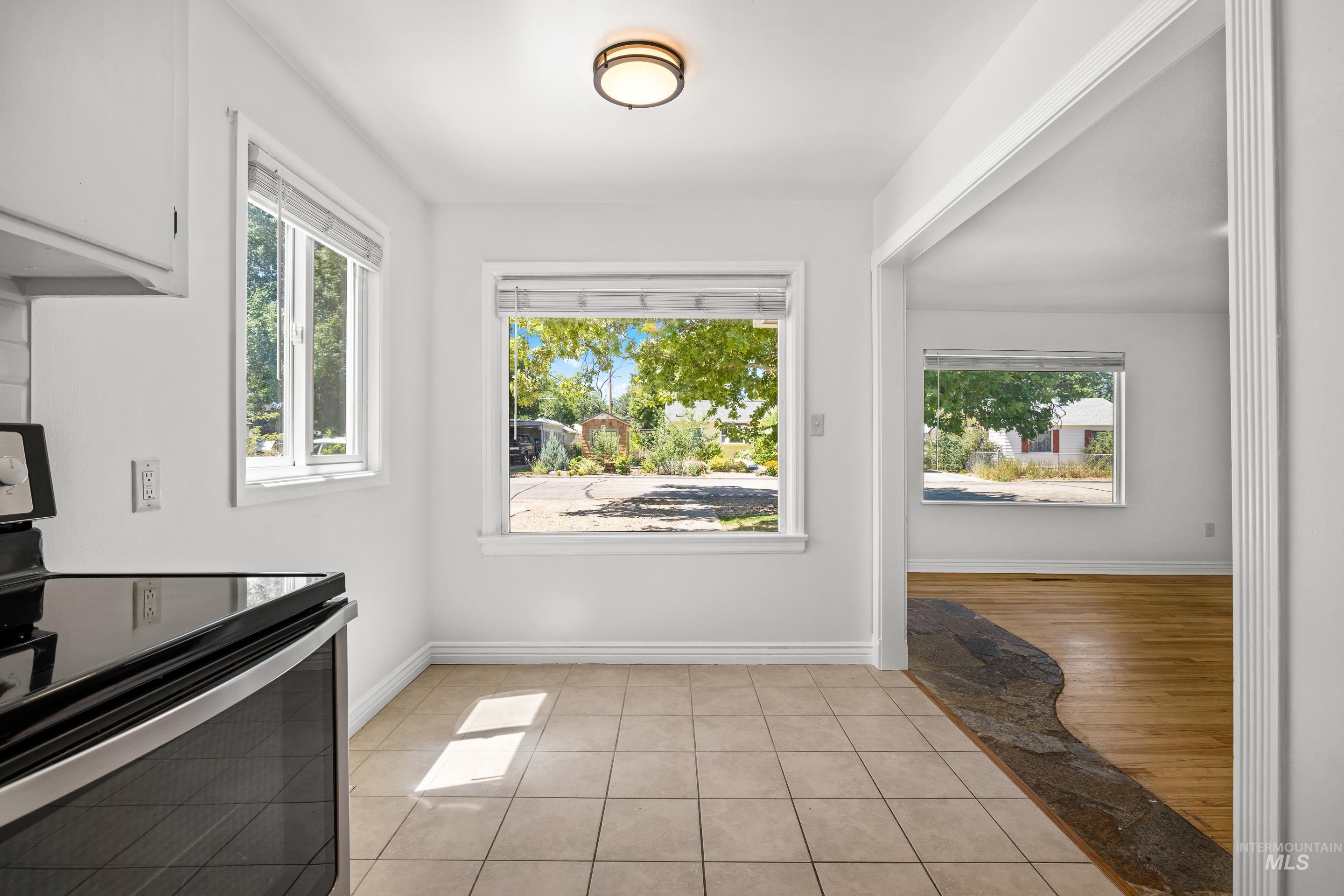 Unfurnished dining area featuring light tile patterned floors and baseboards