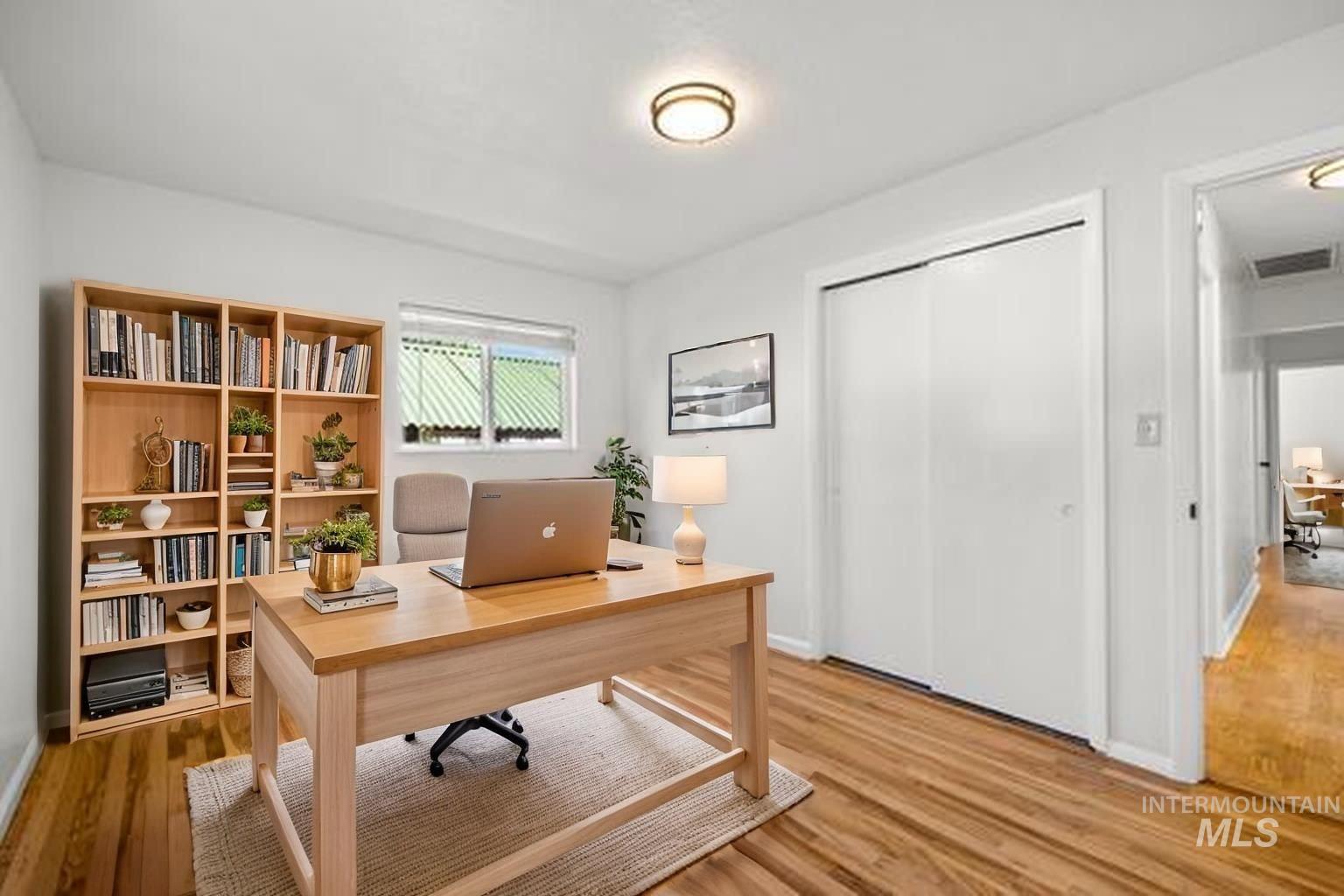 Home office with light wood finished floors and baseboards