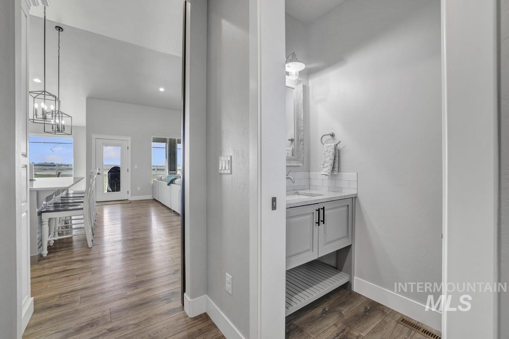 Corridor featuring dark wood-style flooring, a chandelier, and recessed lighting