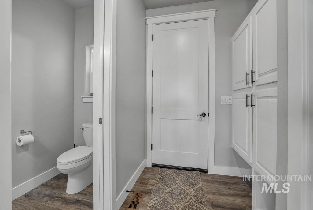 Bathroom featuring baseboards and dark wood-type flooring