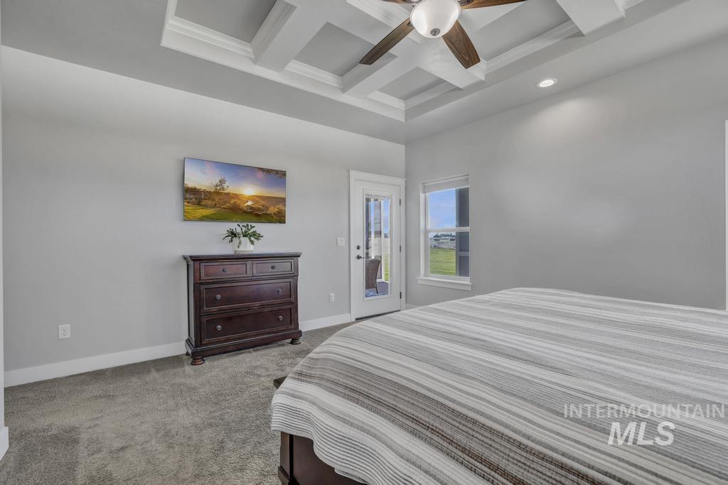 Bedroom featuring beamed ceiling, access to exterior, carpet flooring, coffered ceiling, and ceiling fan