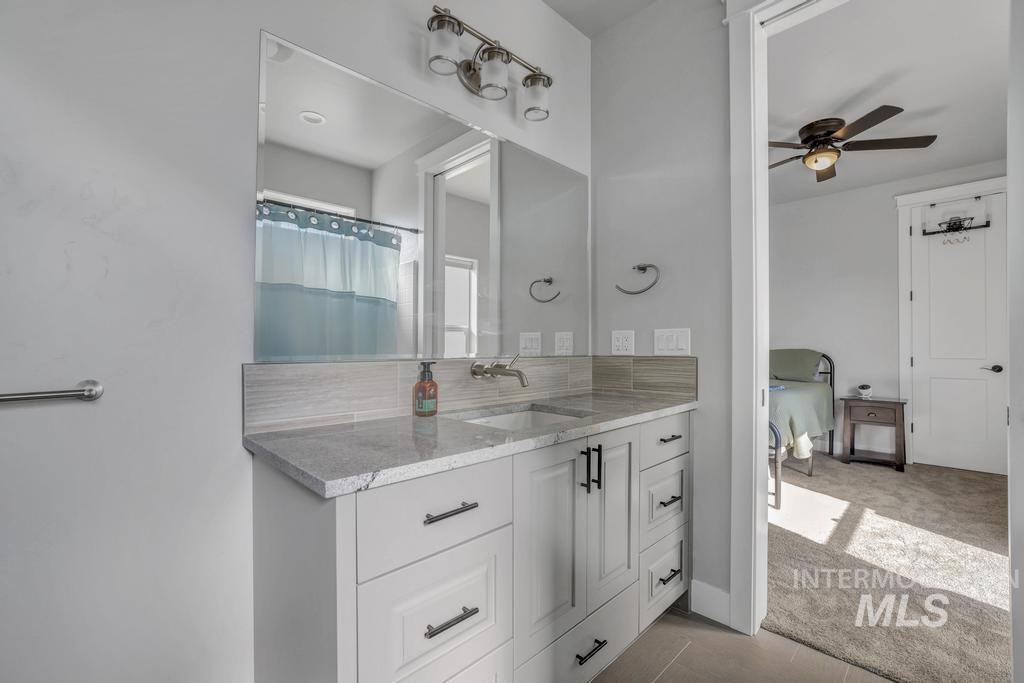 Bathroom featuring vanity, ceiling fan, and curtained shower