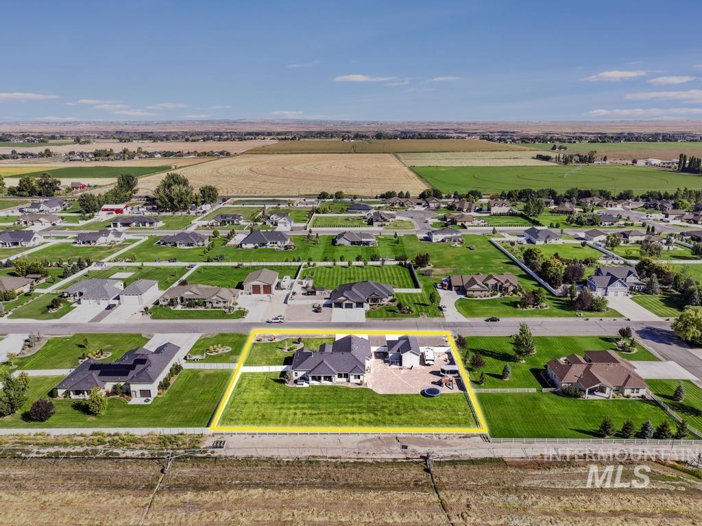 Aerial view of sparsely populated area with property parcel outlined and nearby suburban area