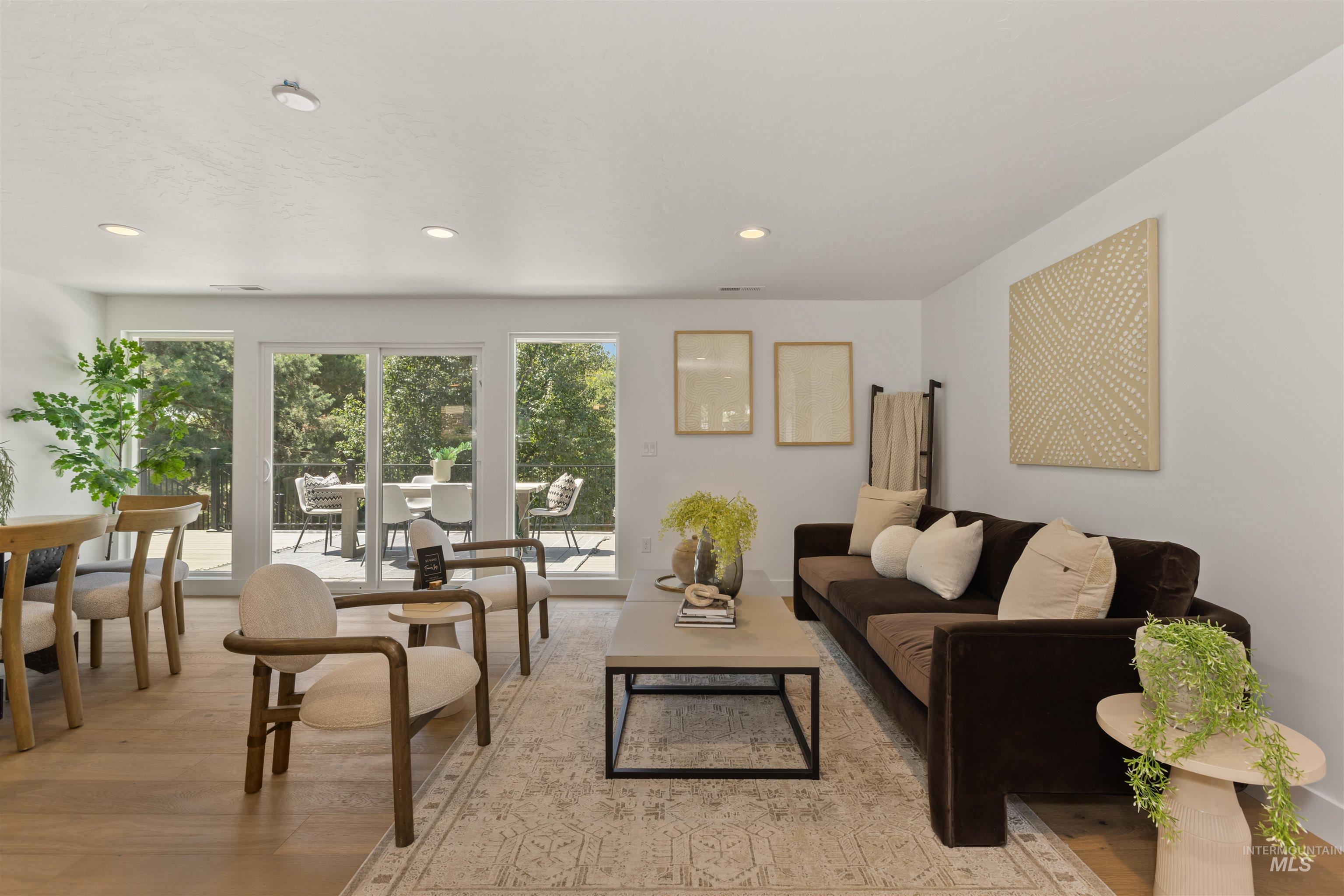 Living area with light wood-style flooring and recessed lighting