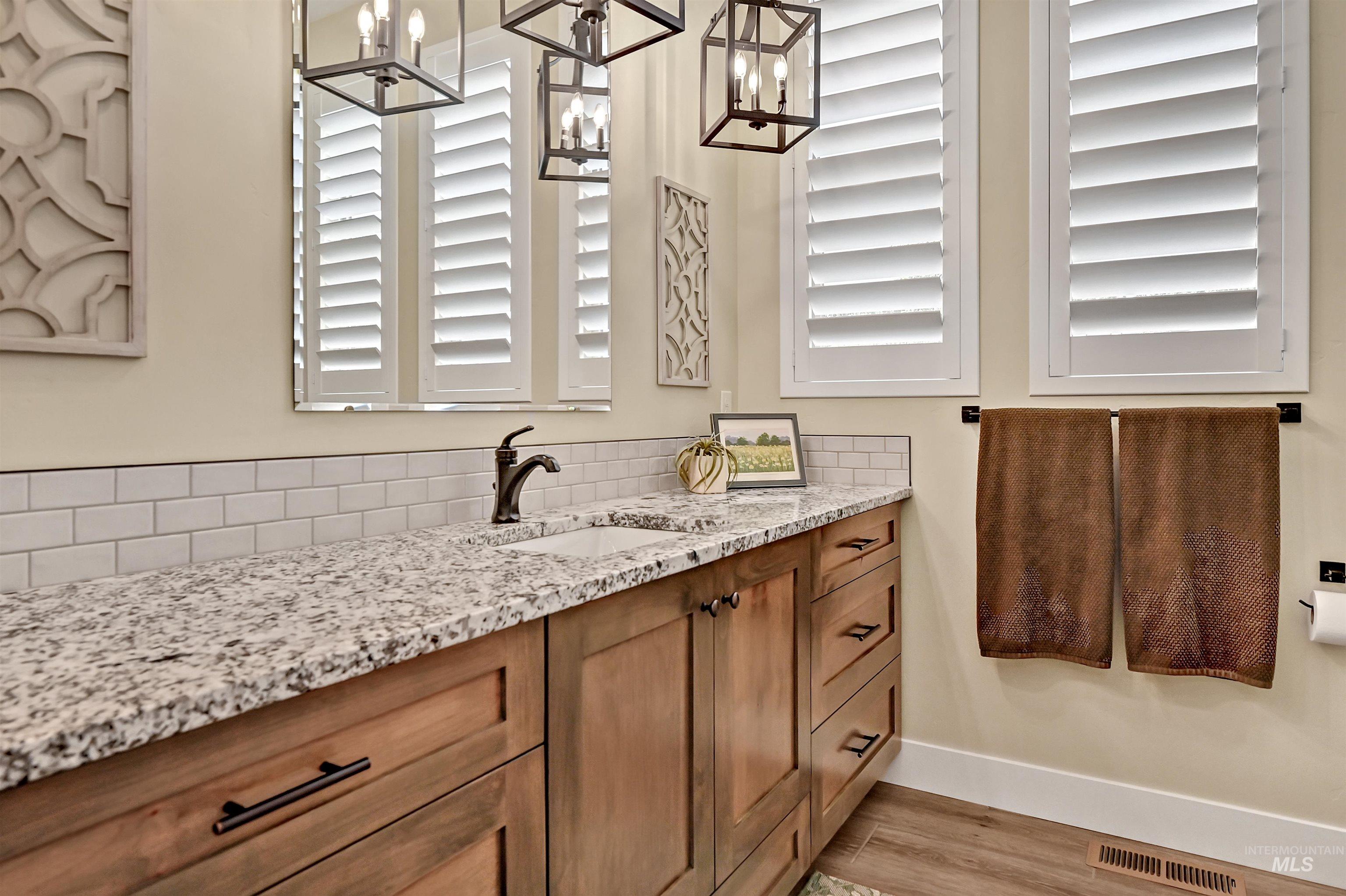 Bathroom with vanity, a chandelier, and wood finished floors