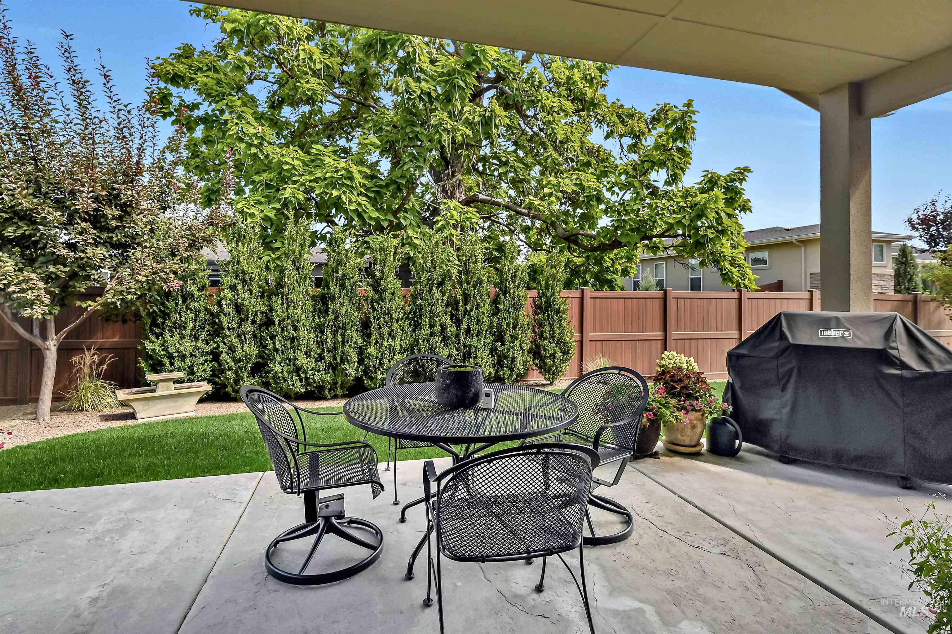 Fenced backyard with area for grilling, a patio, and outdoor dining area