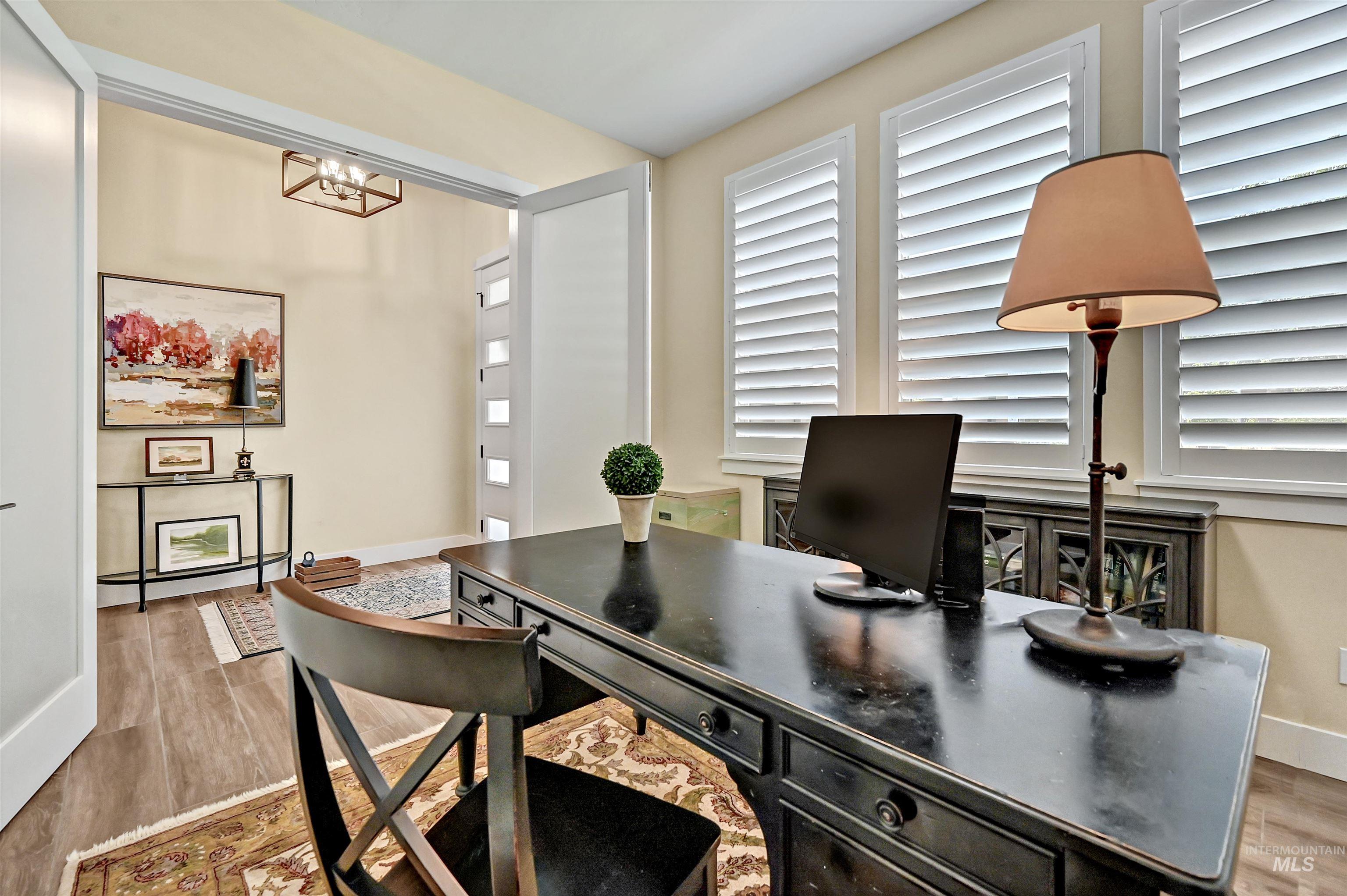 Home office with wood finished floors and a chandelier