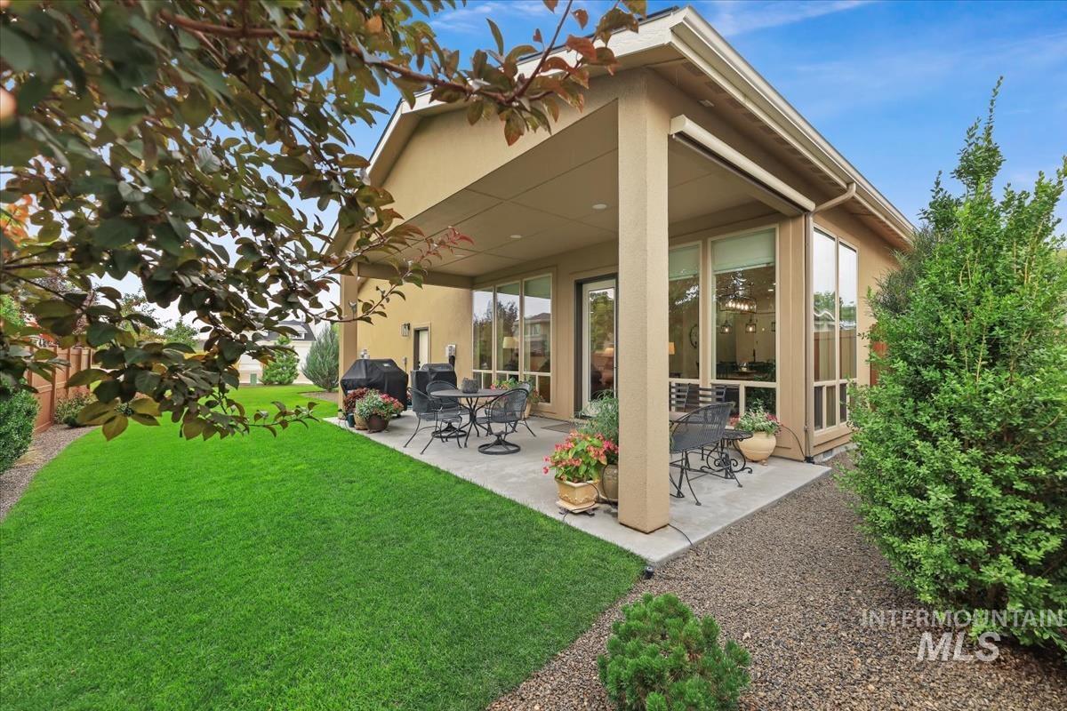 Back of property with a patio area, a yard, and stucco siding