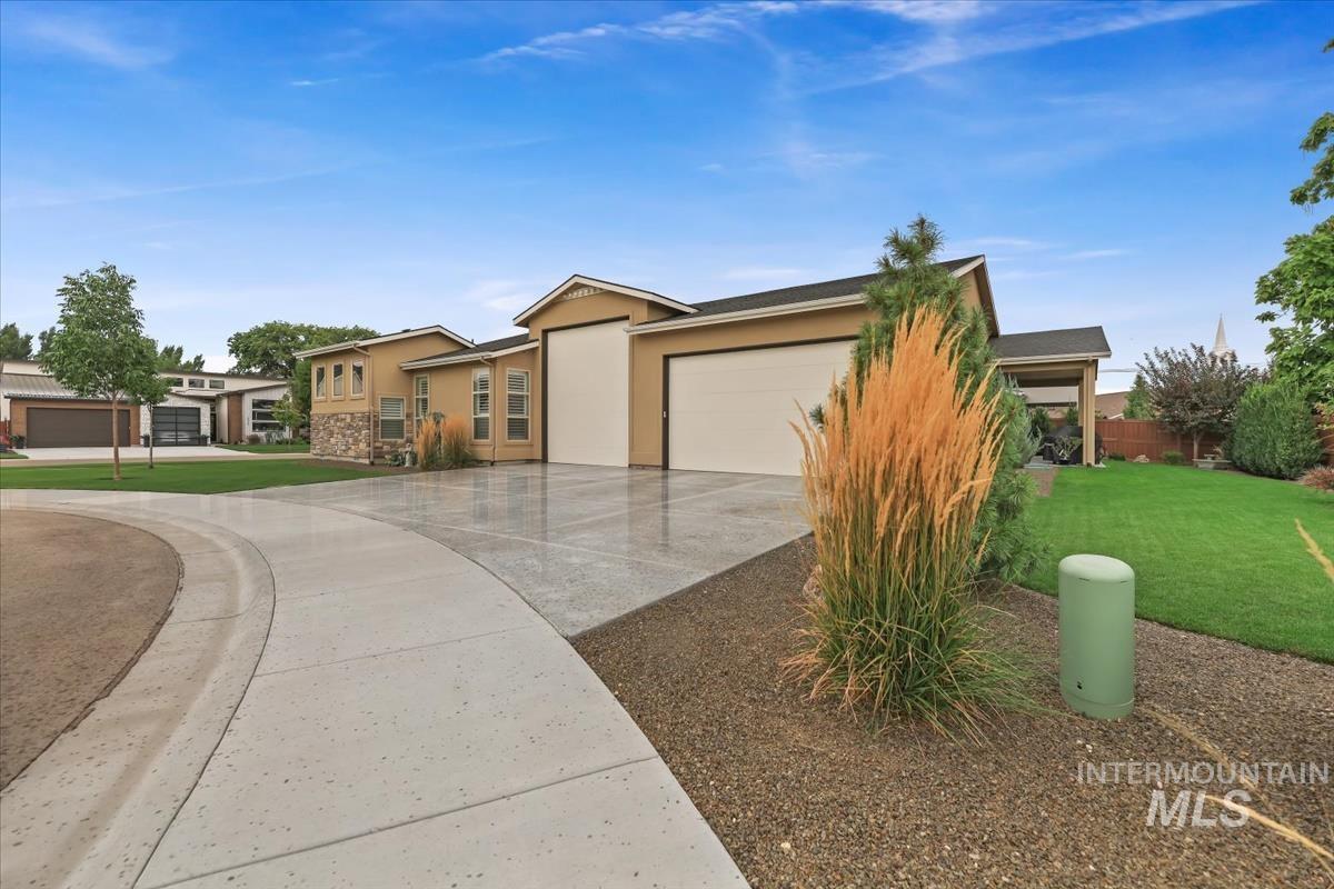 Ranch-style house with a garage, a front lawn, concrete driveway, stucco siding, and stone siding