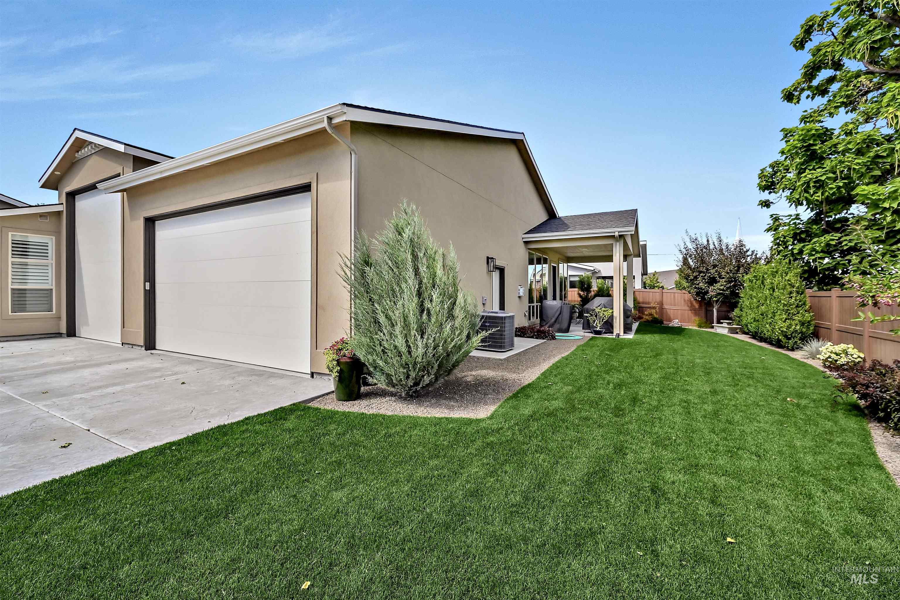 View of side of home featuring a garage, stucco siding, and concrete driveway