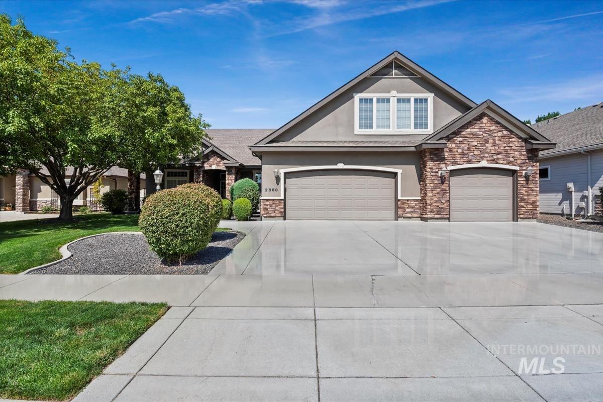 Craftsman inspired home featuring stucco siding, driveway, and stone siding