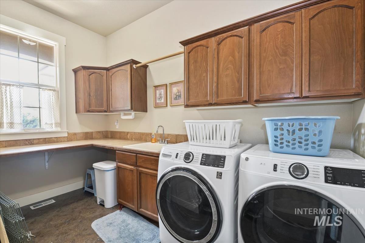Laundry room featuring washer and clothes dryer and cabinet space