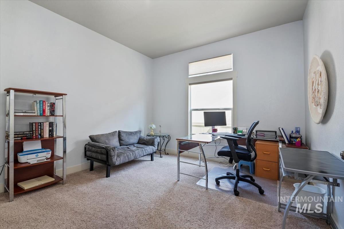 Home office with light colored carpet and baseboards