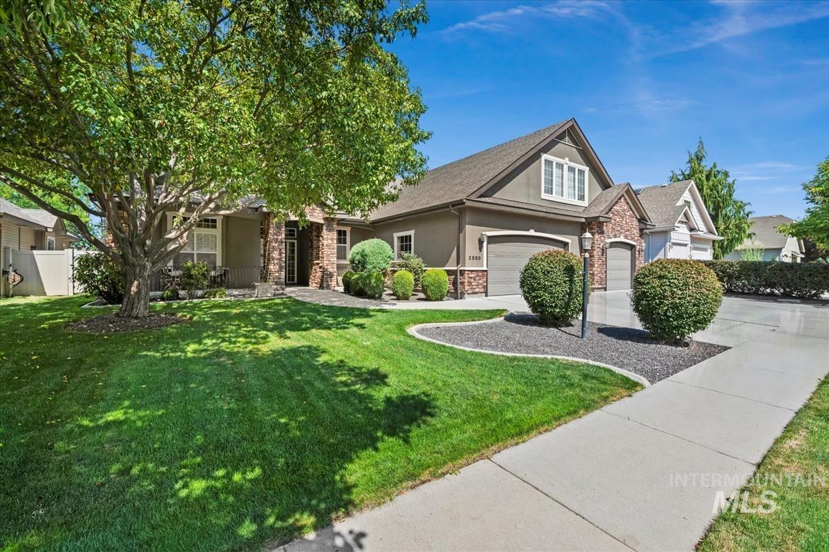 Craftsman house with stucco siding, a garage, driveway, and stone siding