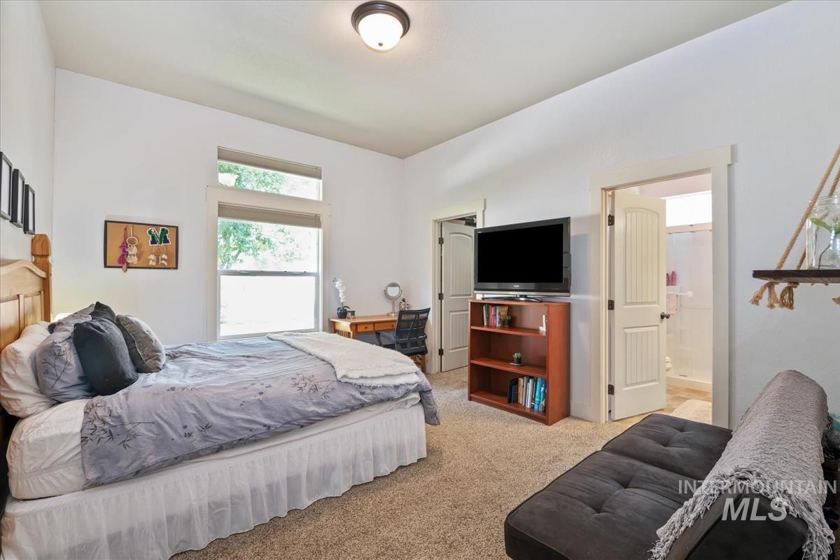 Bedroom featuring light colored carpet and ensuite bathroom