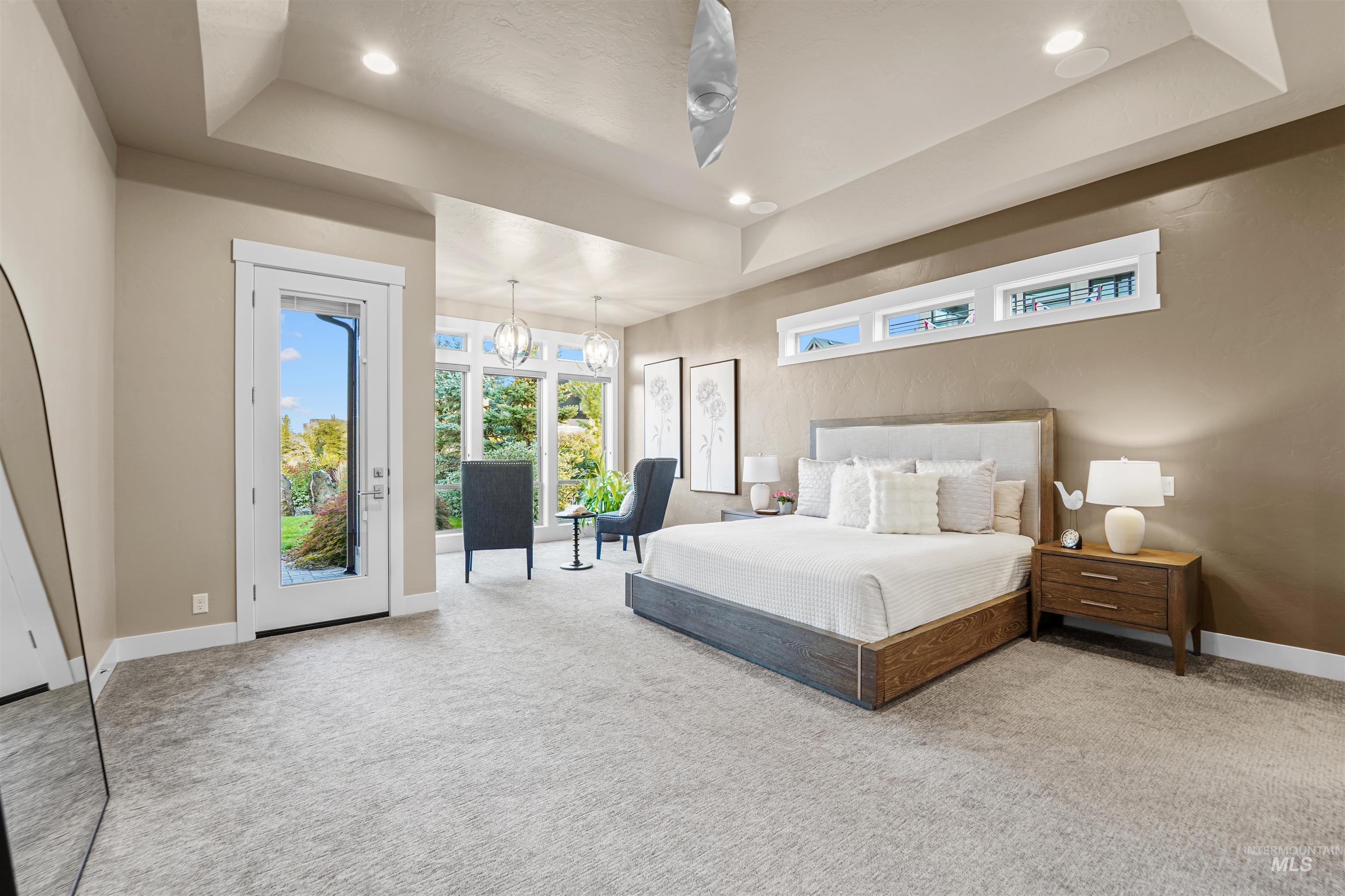 Bedroom featuring a tray ceiling, light colored carpet, access to outside, recessed lighting, and a chandelier