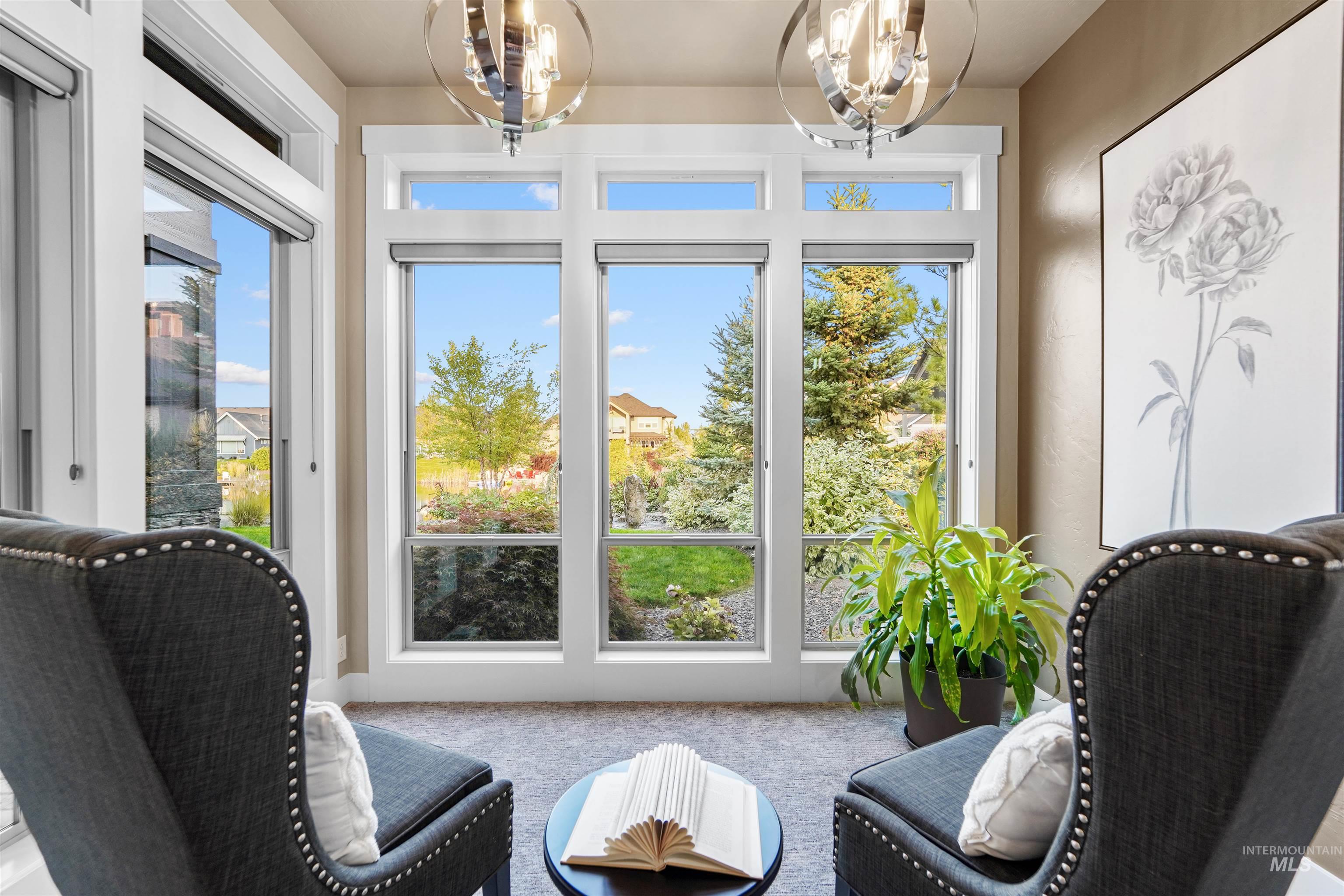 Entryway with carpet floors, a chandelier, and plenty of natural light