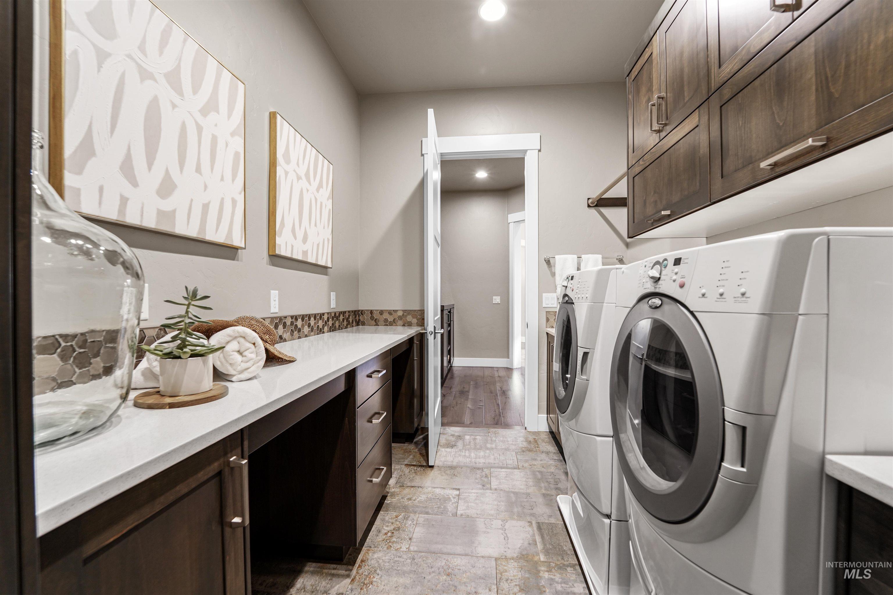 Washroom with cabinet space, washer and dryer, and recessed lighting
