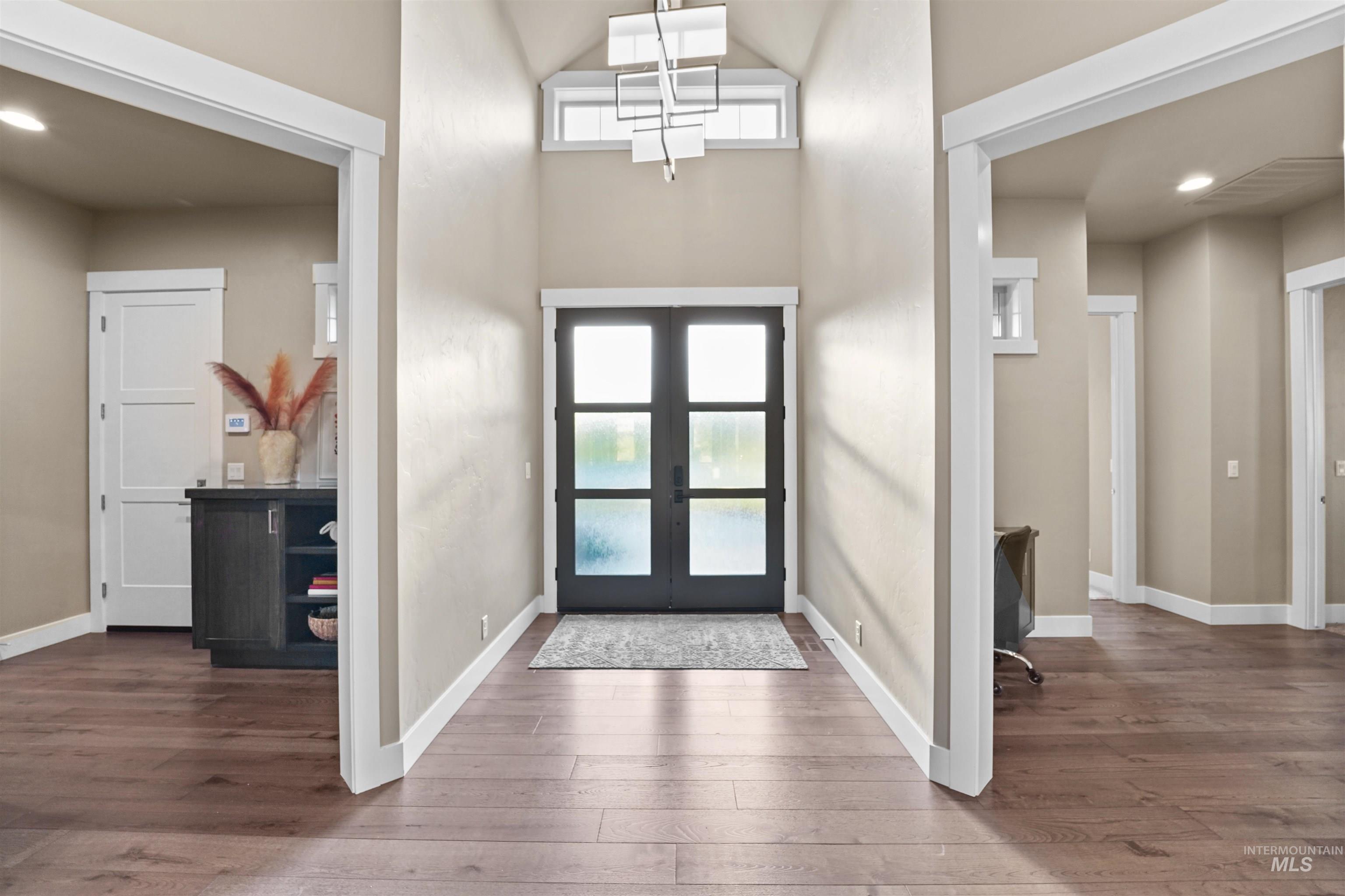 Foyer entrance featuring recessed lighting, a high ceiling, hardwood / wood-style flooring, and french doors