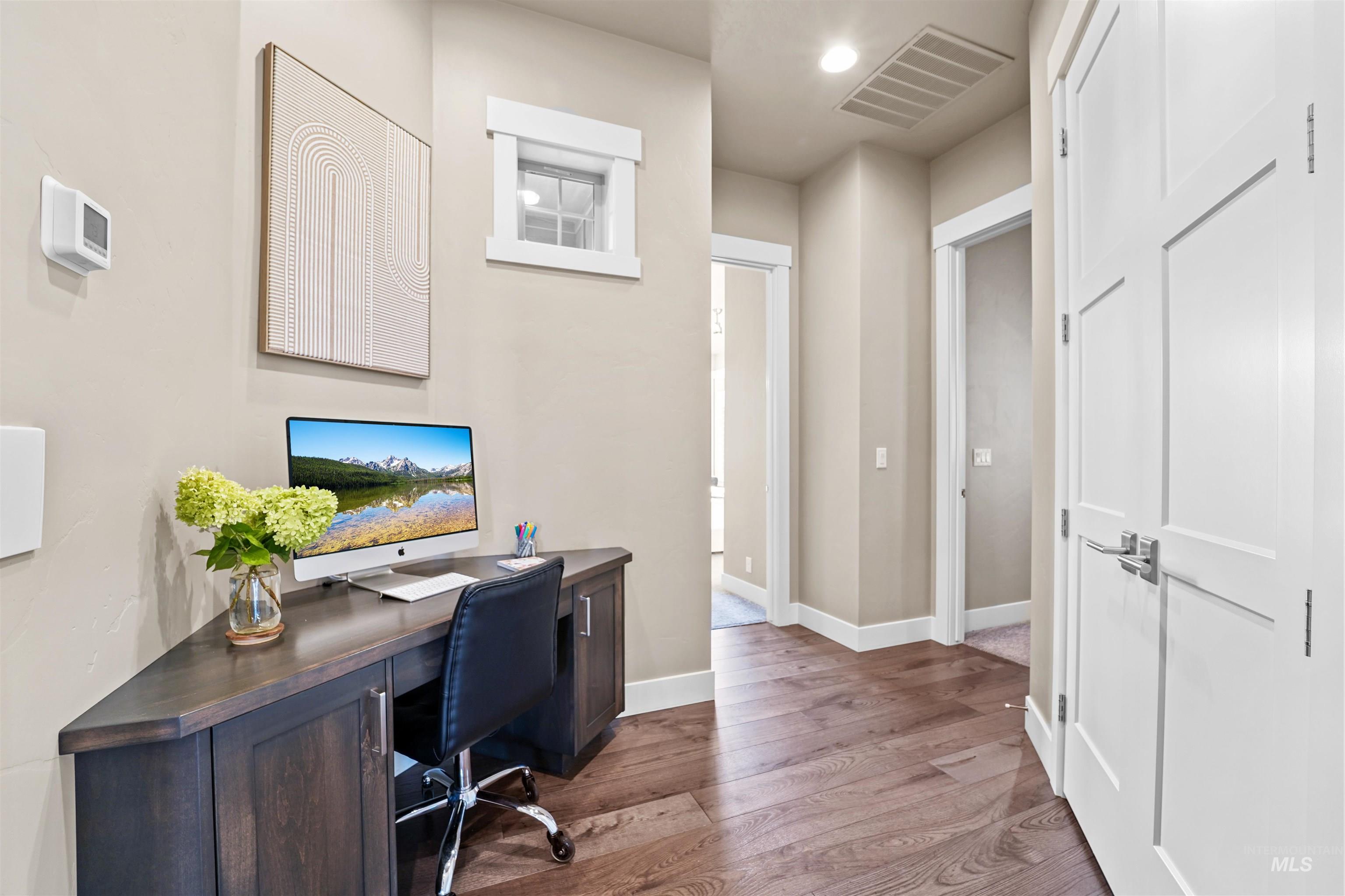 Office area with wood finished floors and recessed lighting