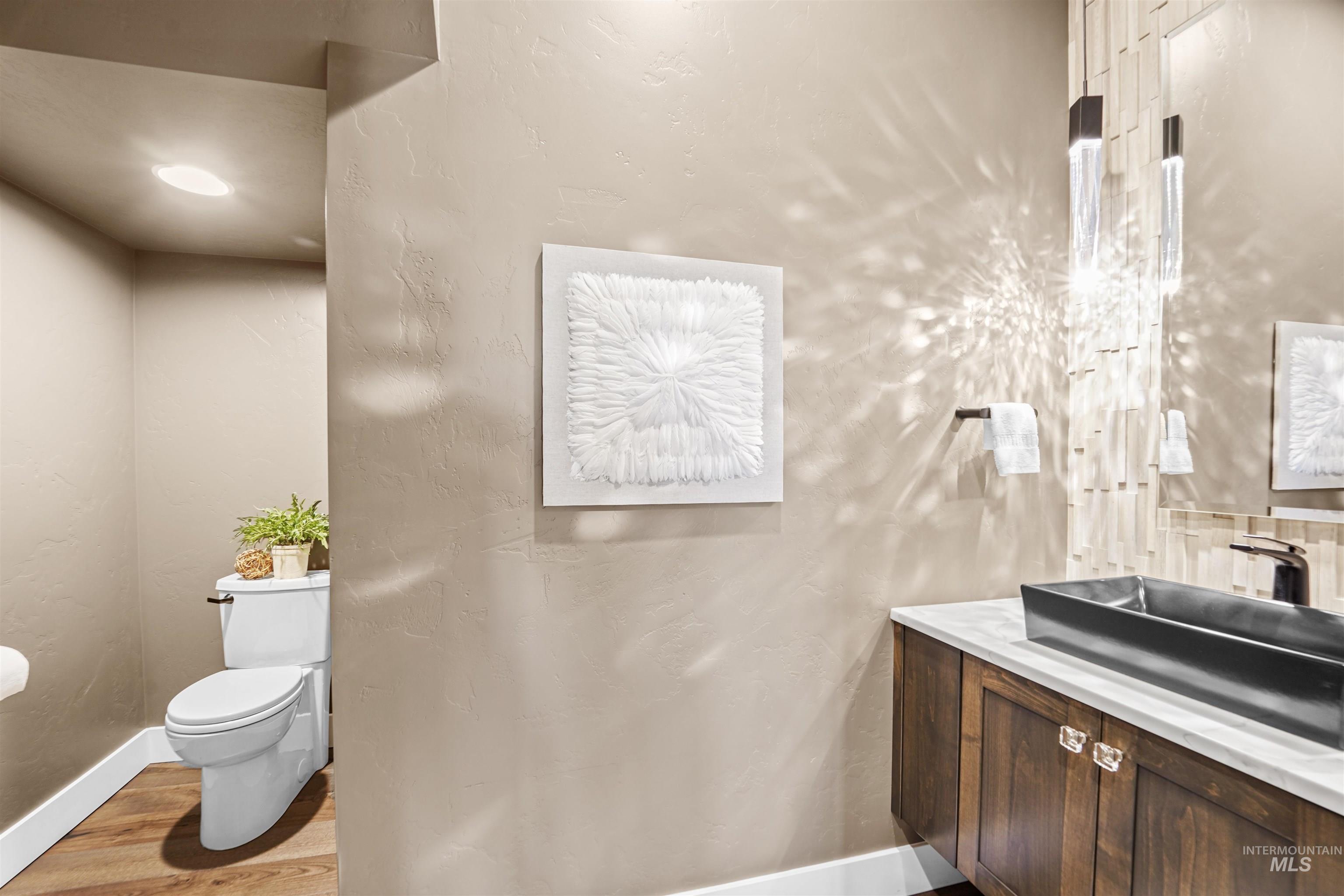 Bathroom featuring vanity, light wood finished floors, and a textured wall