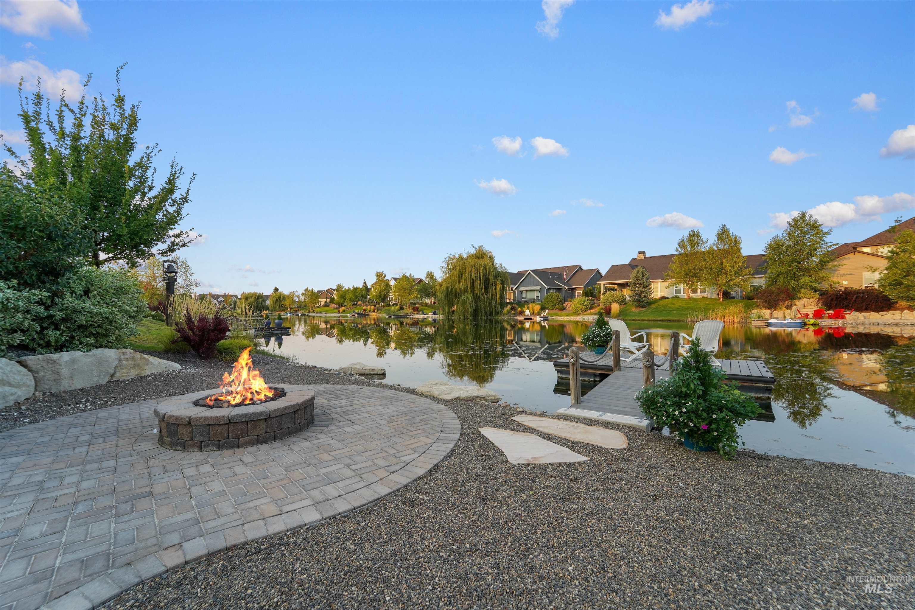 View of yard featuring a water view, a boat dock, a residential view, and an outdoor fire pit