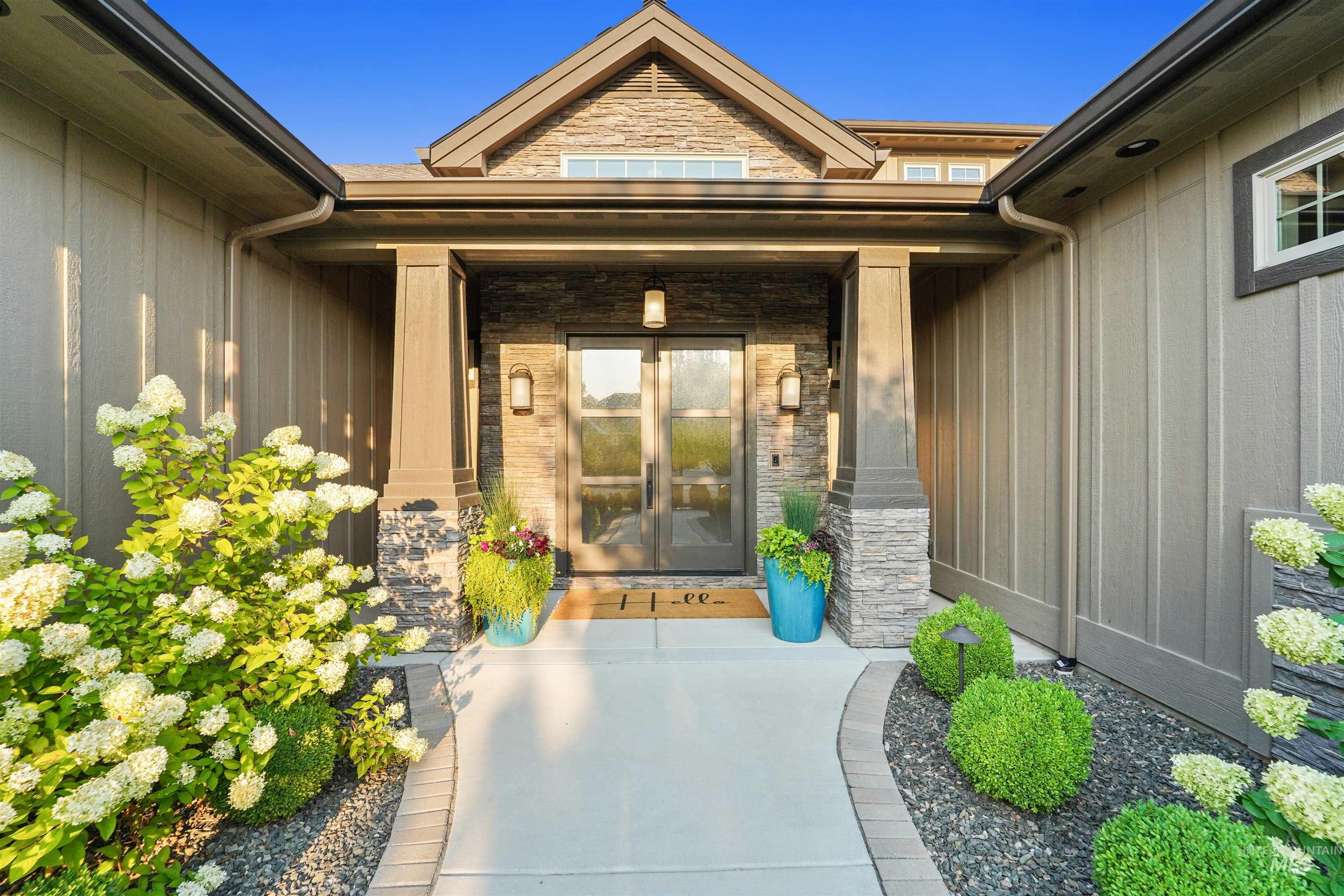 Property entrance featuring stone siding, board and batten siding, and covered porch