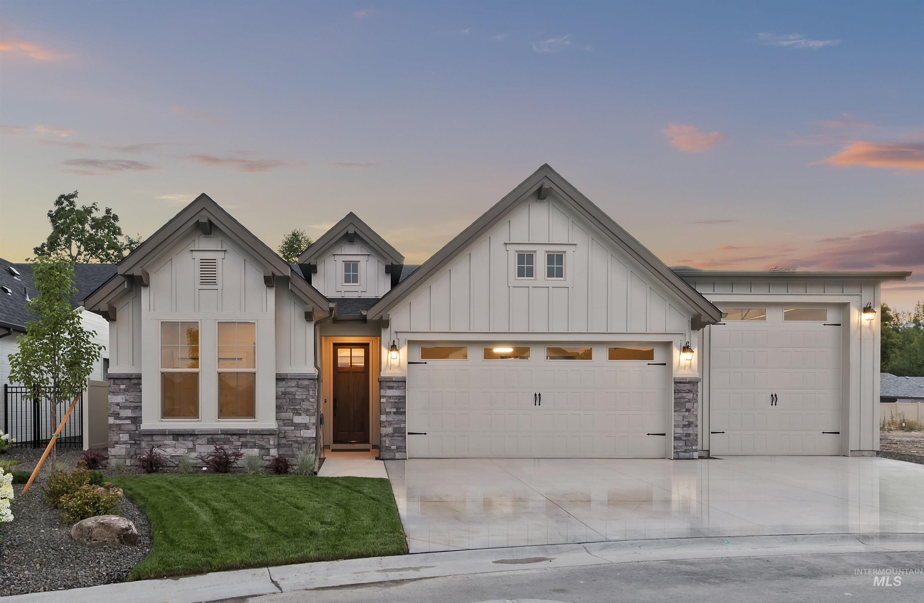 Modern inspired farmhouse with a garage, board and batten siding, and driveway